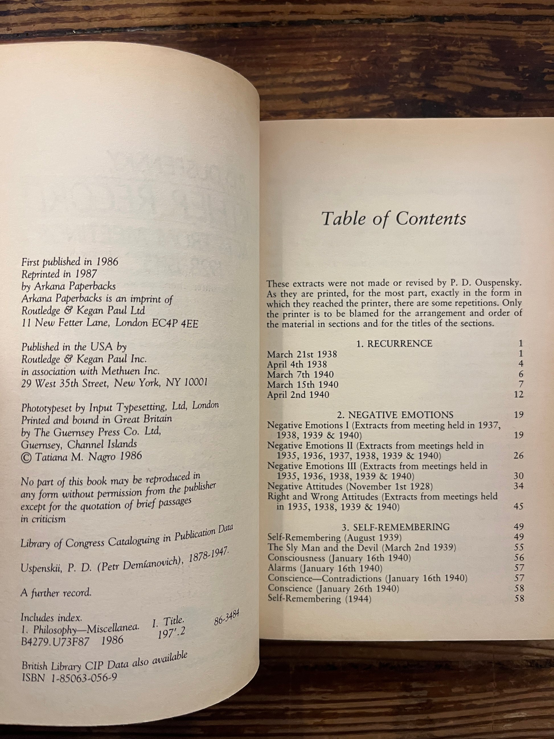 Open book titled 'a further record' by P.D. Ouspensky on a wooden surface 