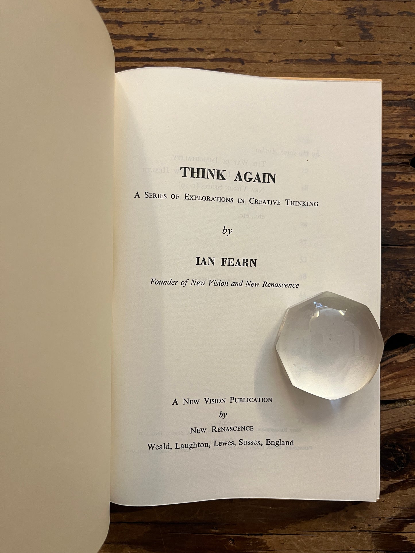 Open book with the title 'Think Again' by Ian Fearn on a wooden surface