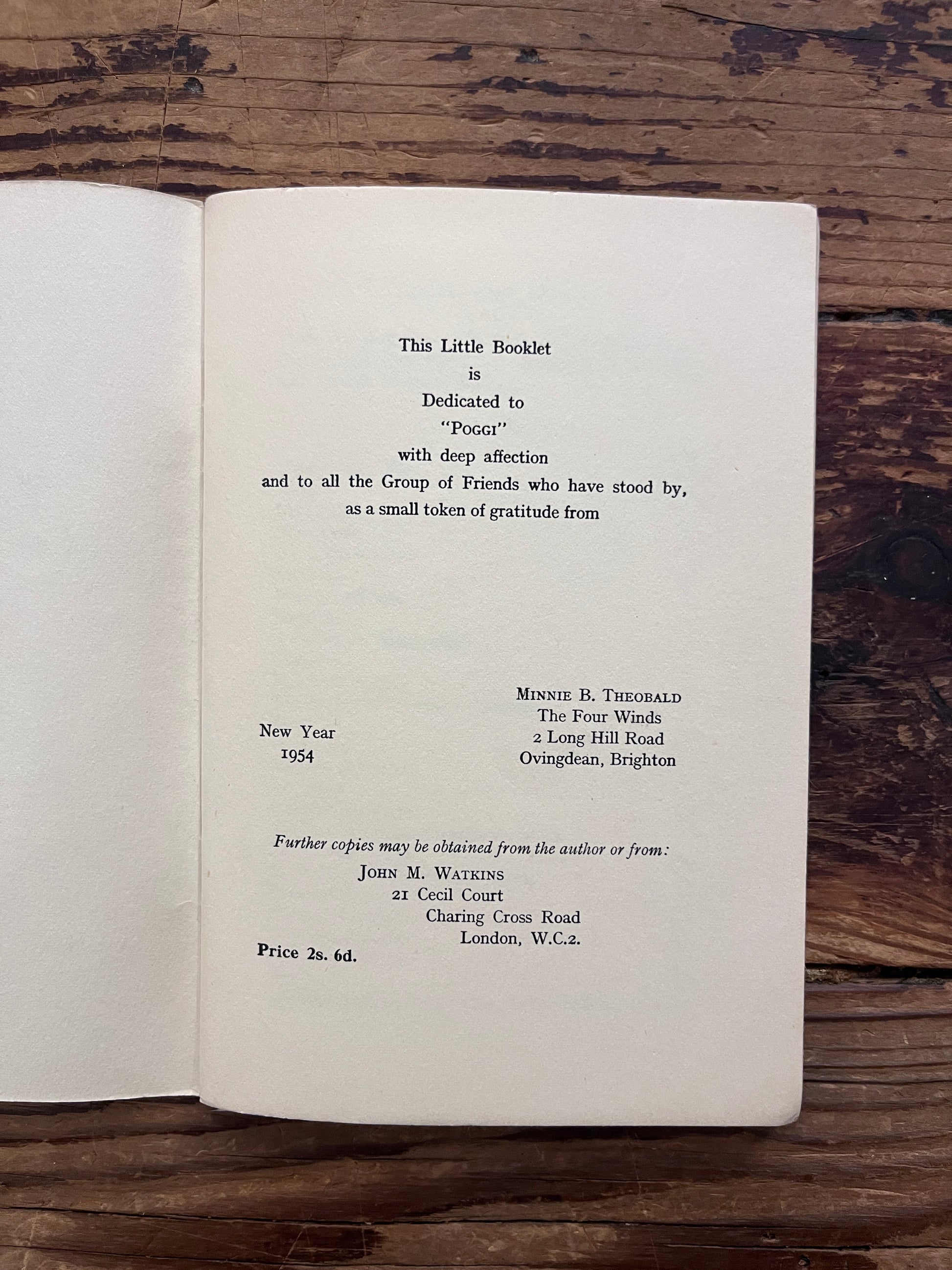 Open booklet with the title 'Death and After' by Minnie B. Theobald on a wooden surface 