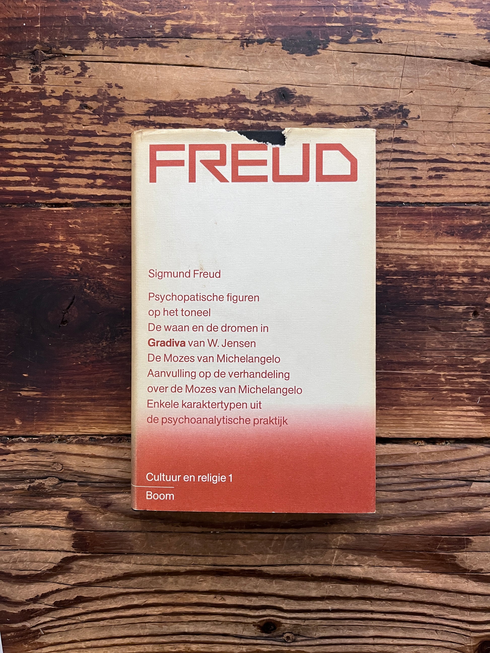 Voorkant van boek met de titel 'Freud, cultuur en religie 1'  door Sigmund Freud op een houten achtergrond 