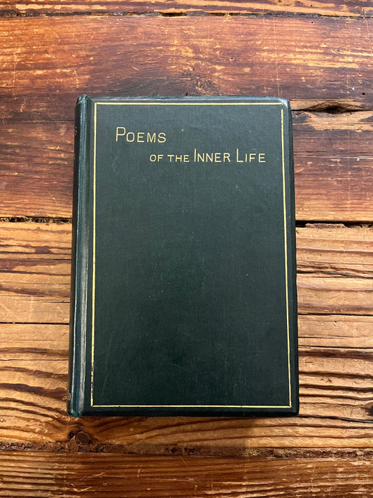 Front cover of book titled 'Poems of the Inner Life' on a wooden surface