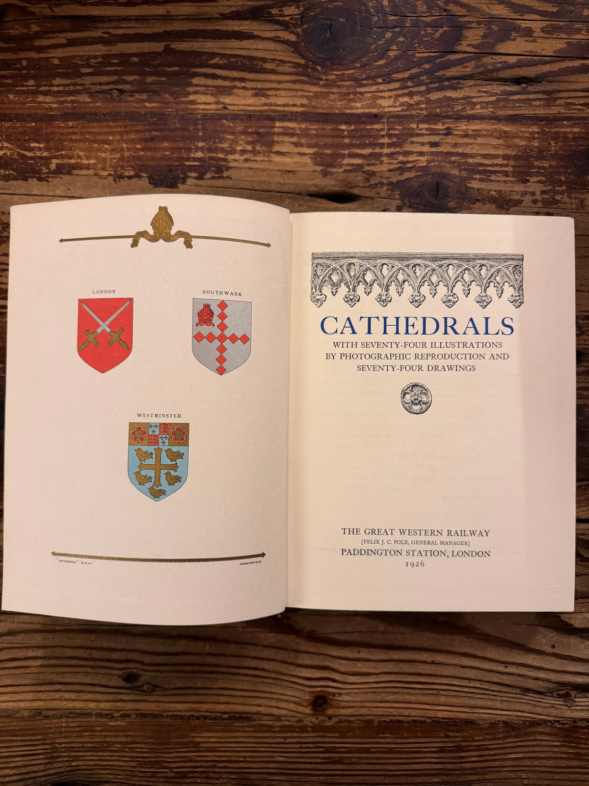 Open book titled 'Cathedrals' from 1926 from the series made by 'The Great Western Railway' on a wooden surface