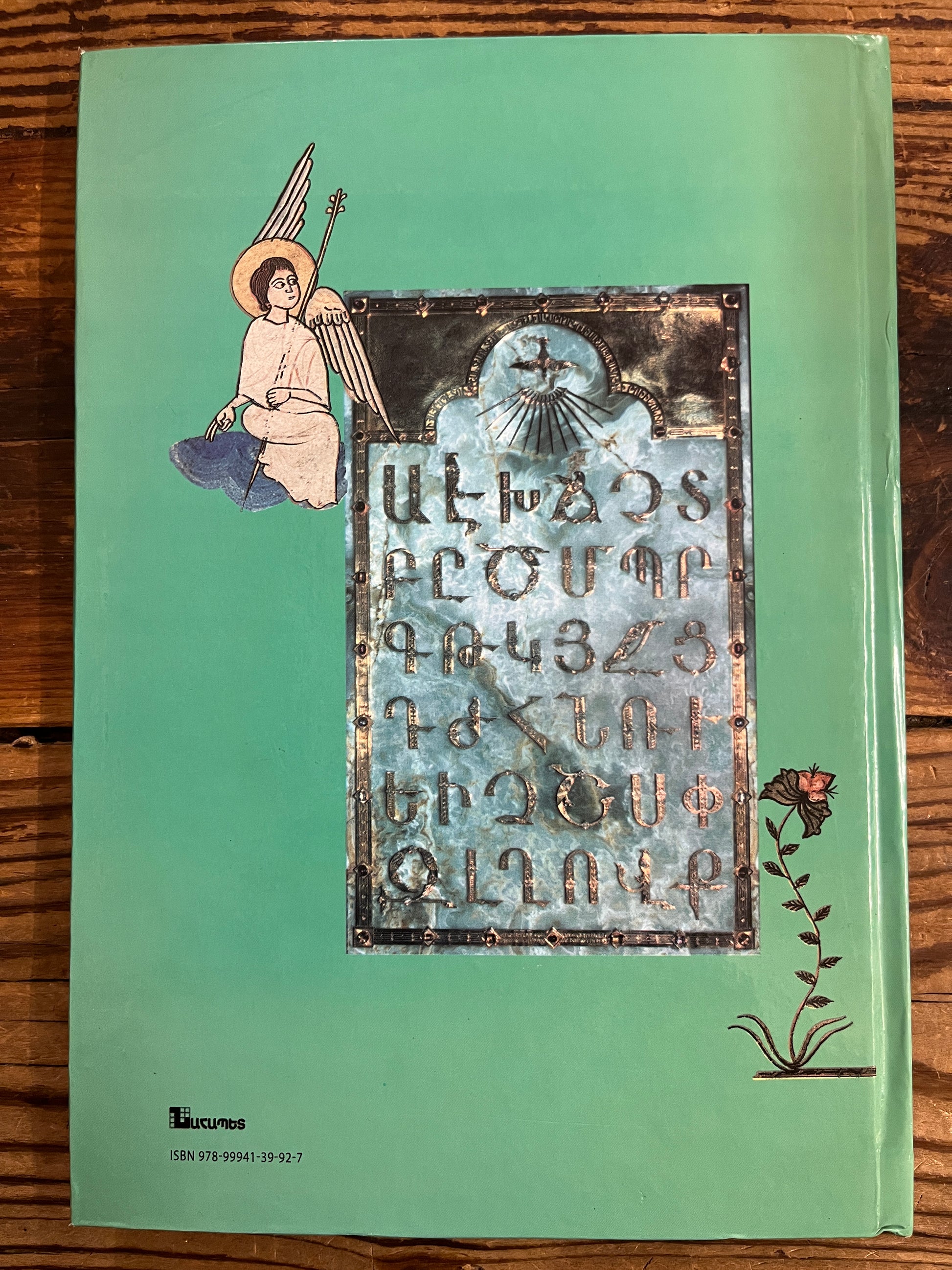 Back cover of book titled 'Folktales of Armenia' on a wooden surface