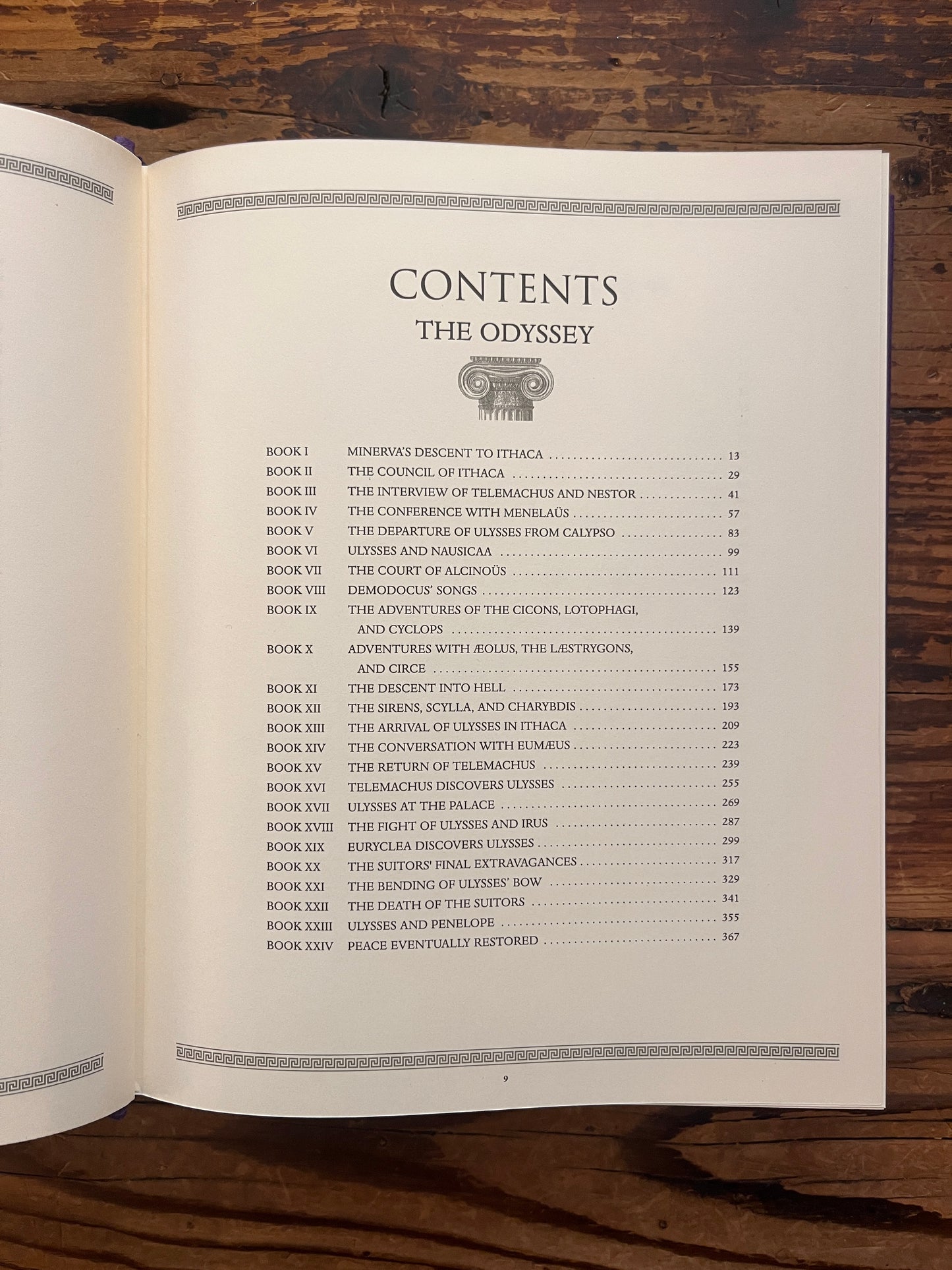 Open book titled 'The Odyssey' by Homer and translated by A. Pope, sowing the contents, on a wooden surface