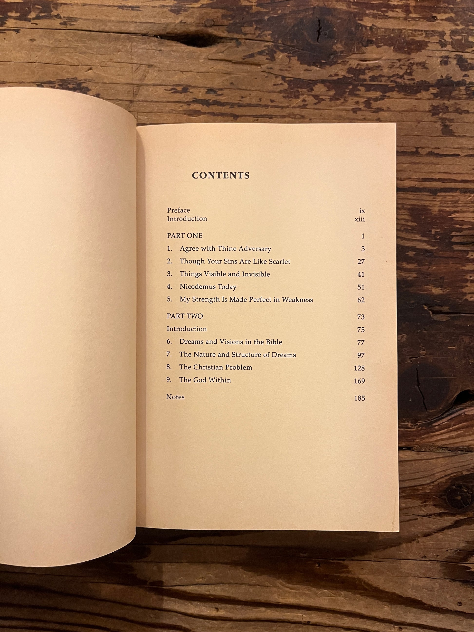 Open book titled 'Dreams: God's Forgotten Language' by John A. Sanford on a wooden surface