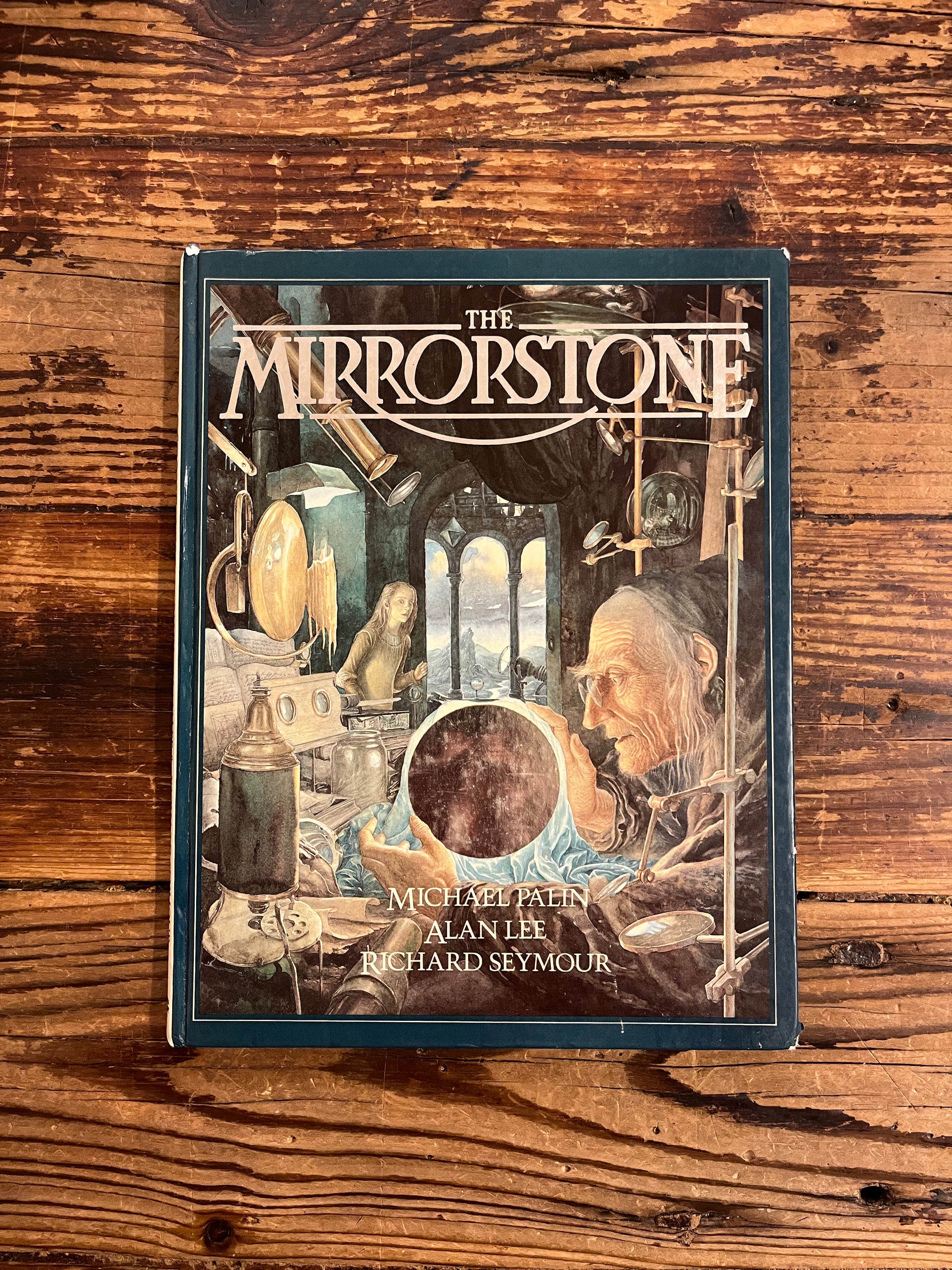 Book titled 'The Mirrorstone' on a wooden surface