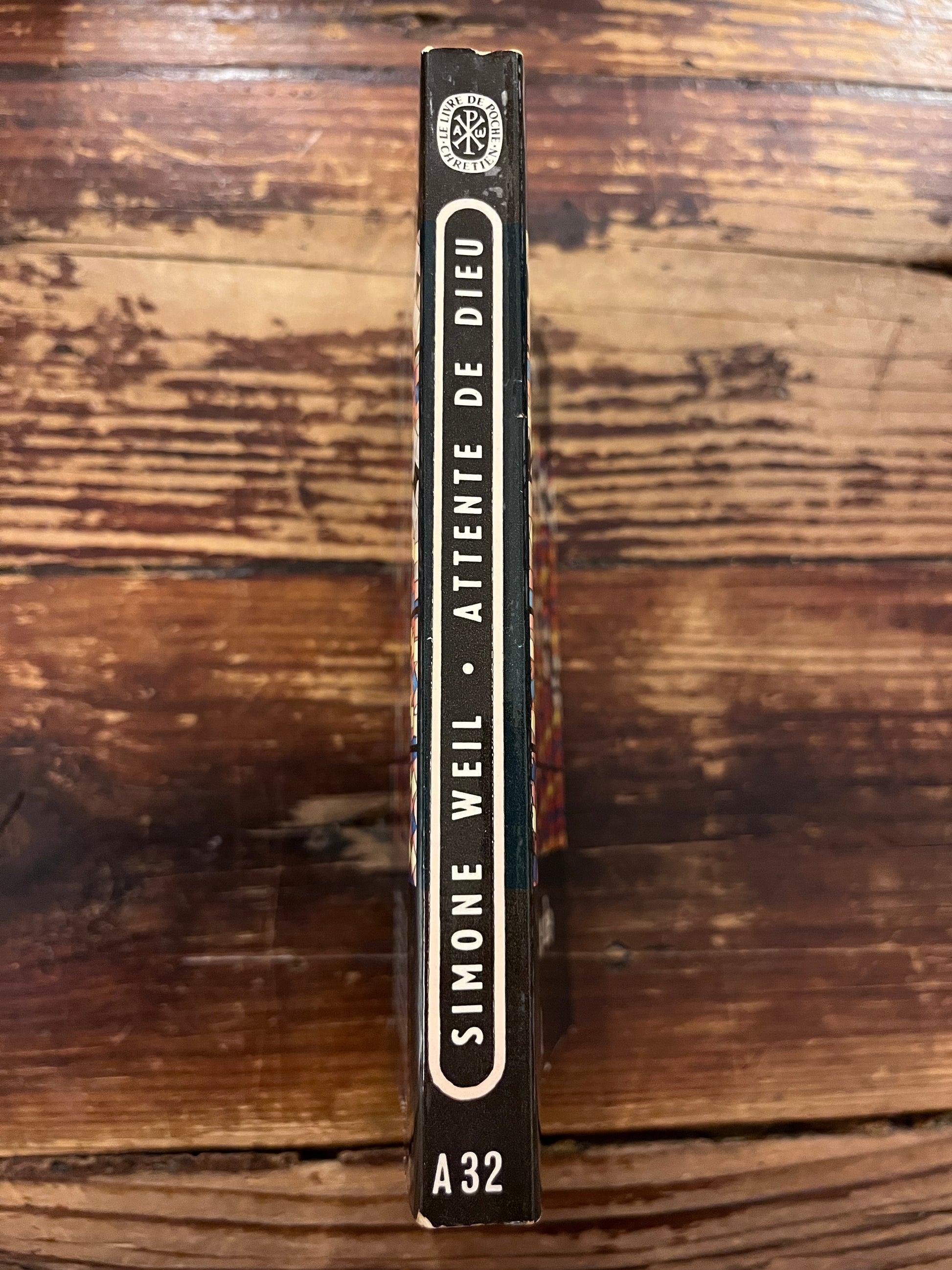 photo du dos du livre "dans l'attente de dieu"sur fond de bois