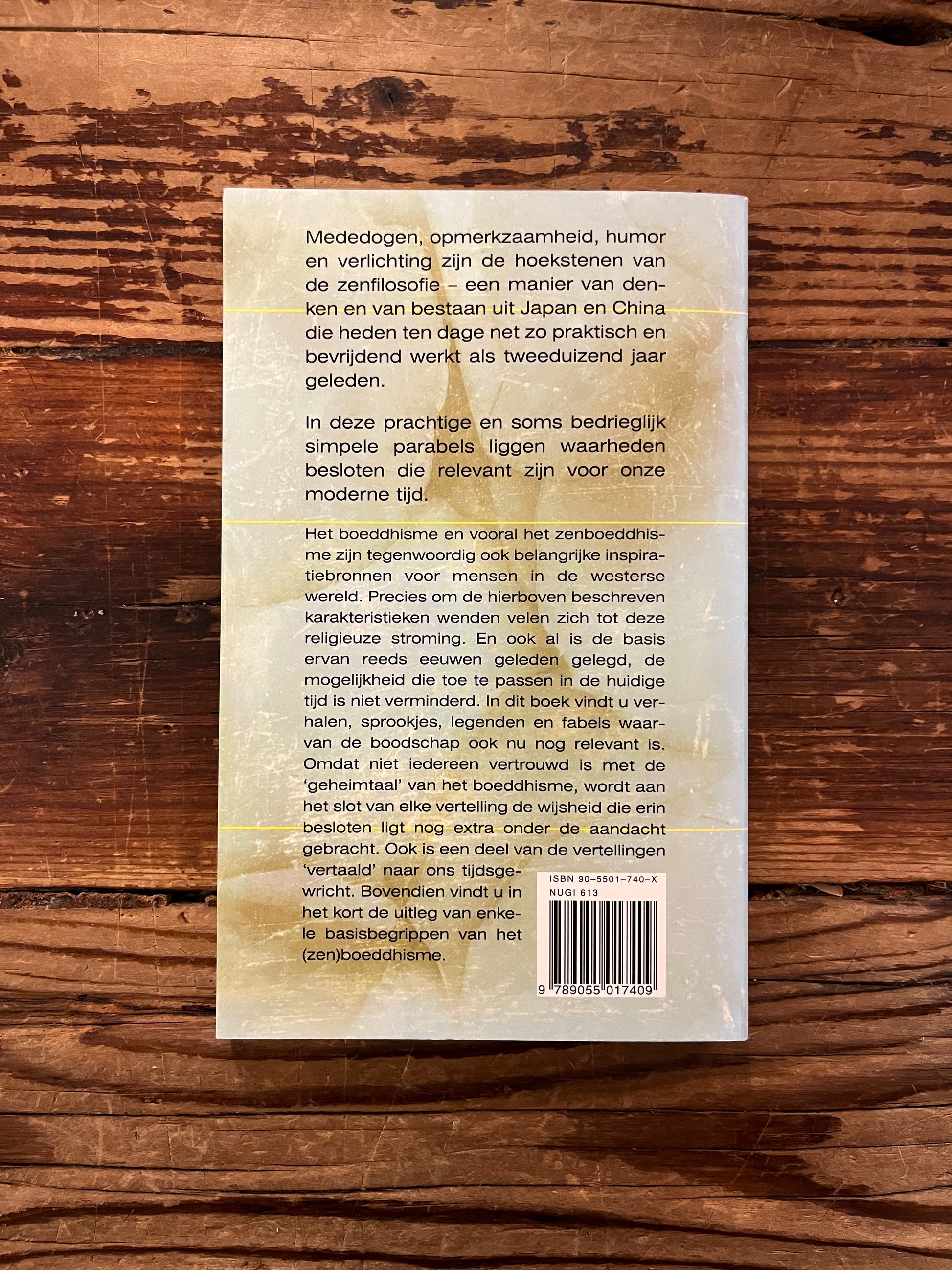 Achterkant van boek met de titel 'Zen-fabels' op een houten achtergrond 