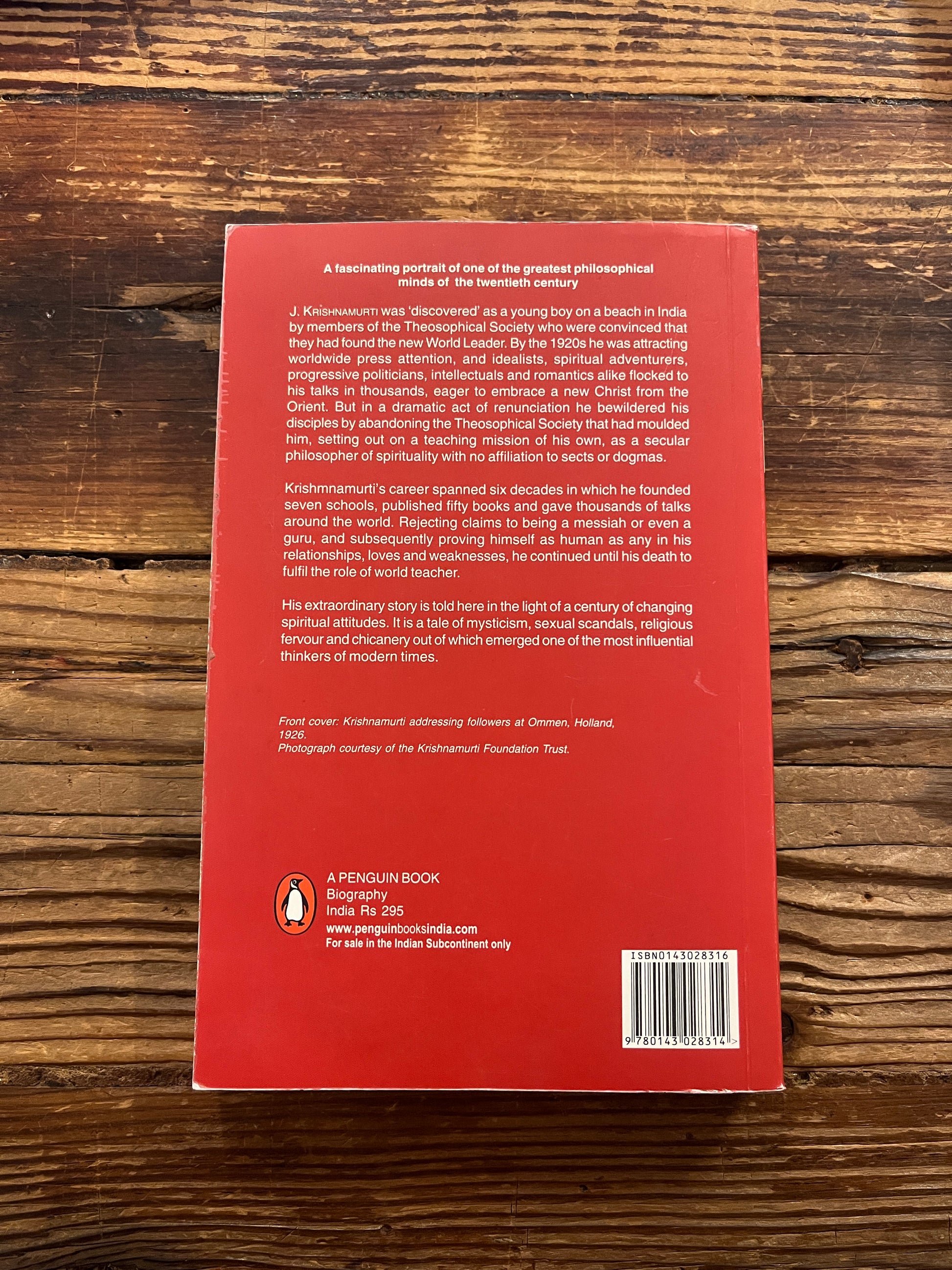 Back cover of book titled 'star in the East, Krishnamurti' by Roland Vernon on a wooden surface