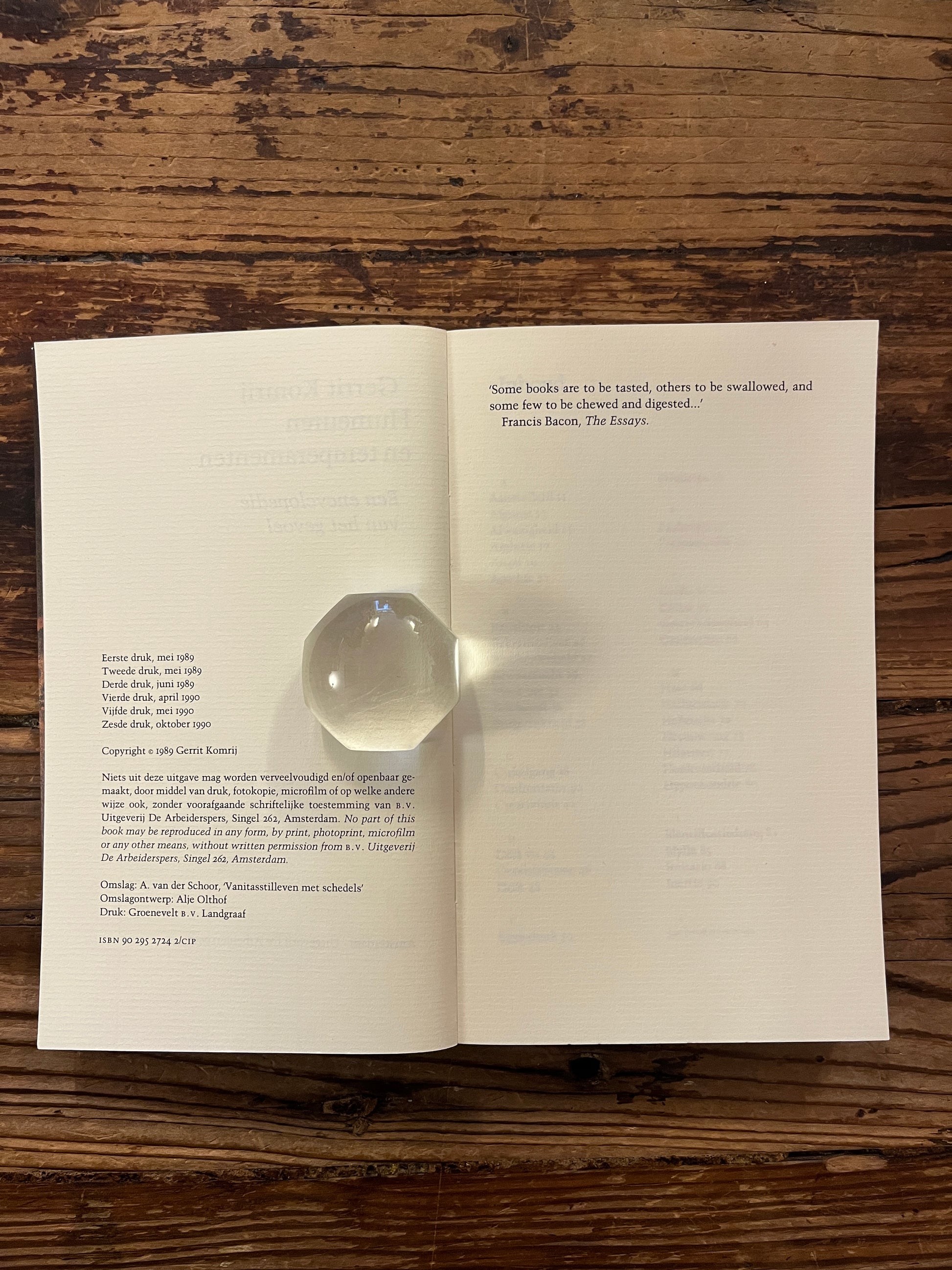 Open boek met de titel 'humeuren & temperamenten' door Gerrit Komrij op een houten achtergrond 