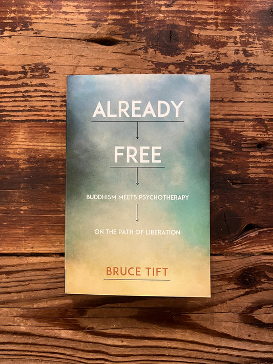 Book titled 'Already Free' by Bruce Tift on a wooden surface