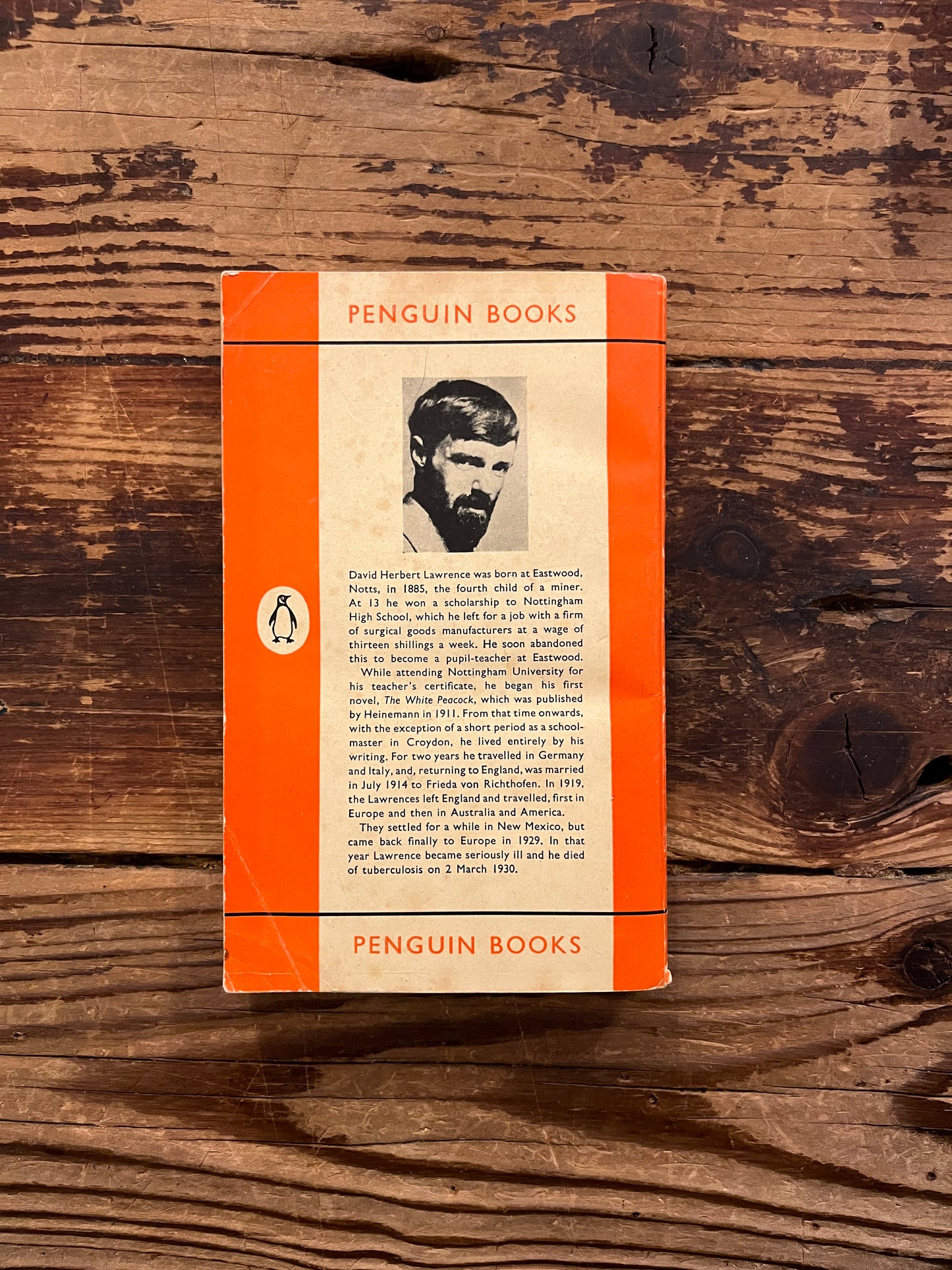 Back cover of book titled 'Lady Chatterley's Lover' by D.H. Lawrence on a wooden surface
