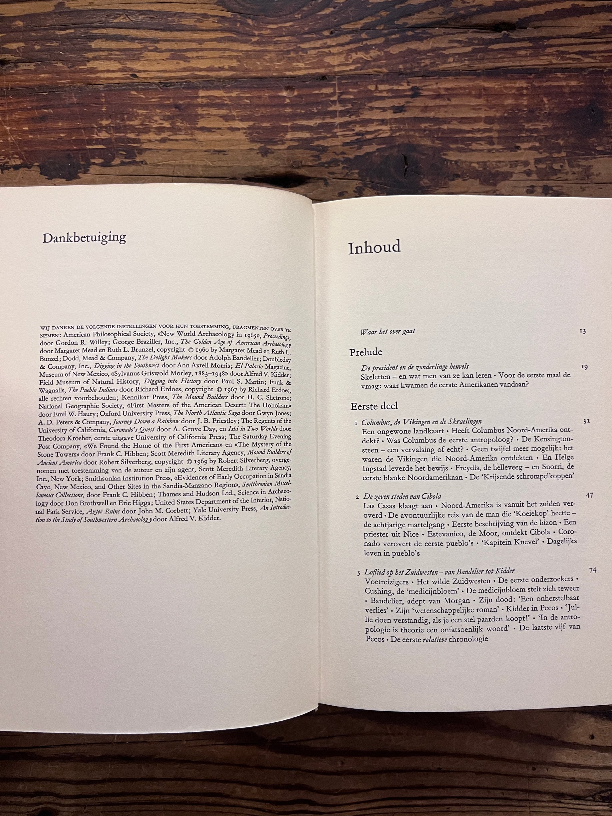 Open hardcover boek met de titel 'De Eerste Amerikaan' by C.W. Ceram op een houten achtergrond 