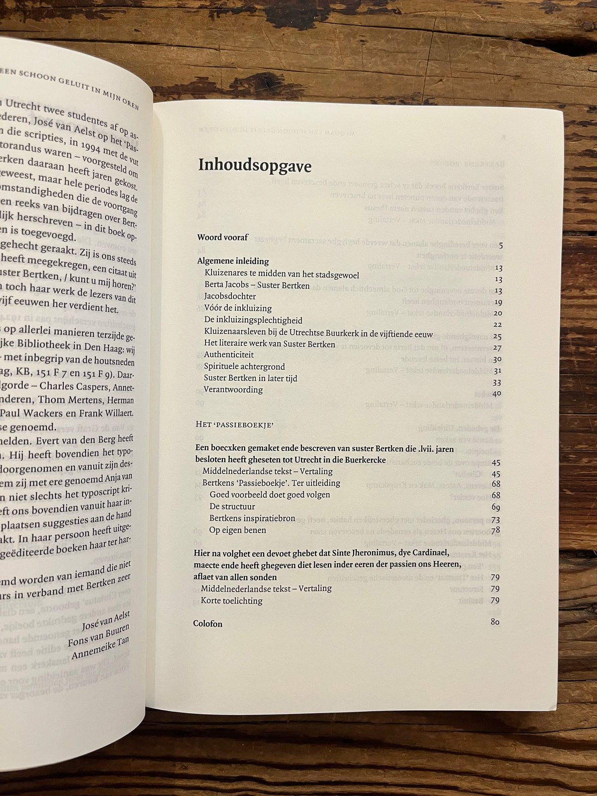 Open boek met de titel 'het werk van Suster Bertken' op een houten achtergrond