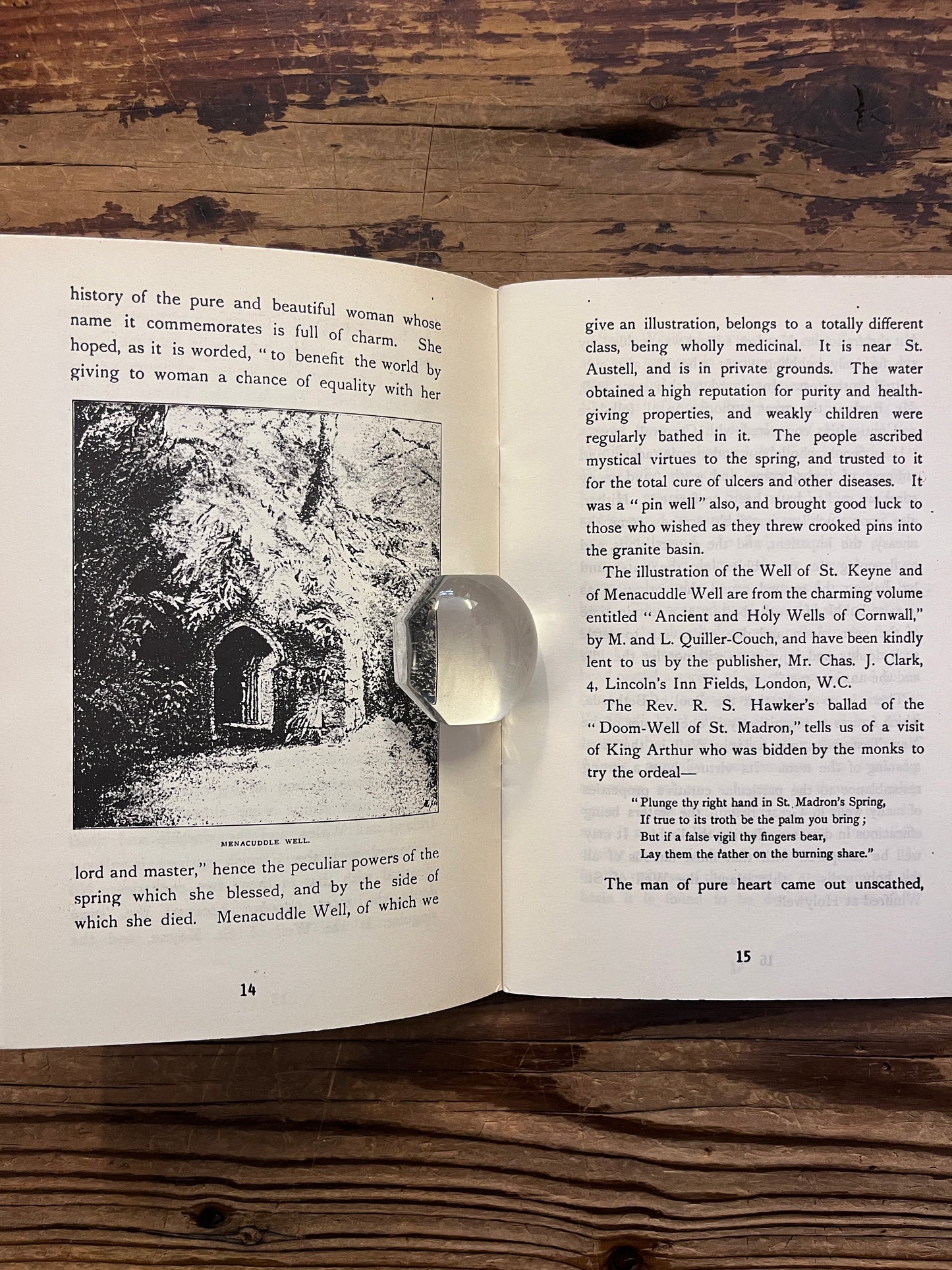 Open booklet titled 'Holy Wells' by Cuming Walters on a wooden surface