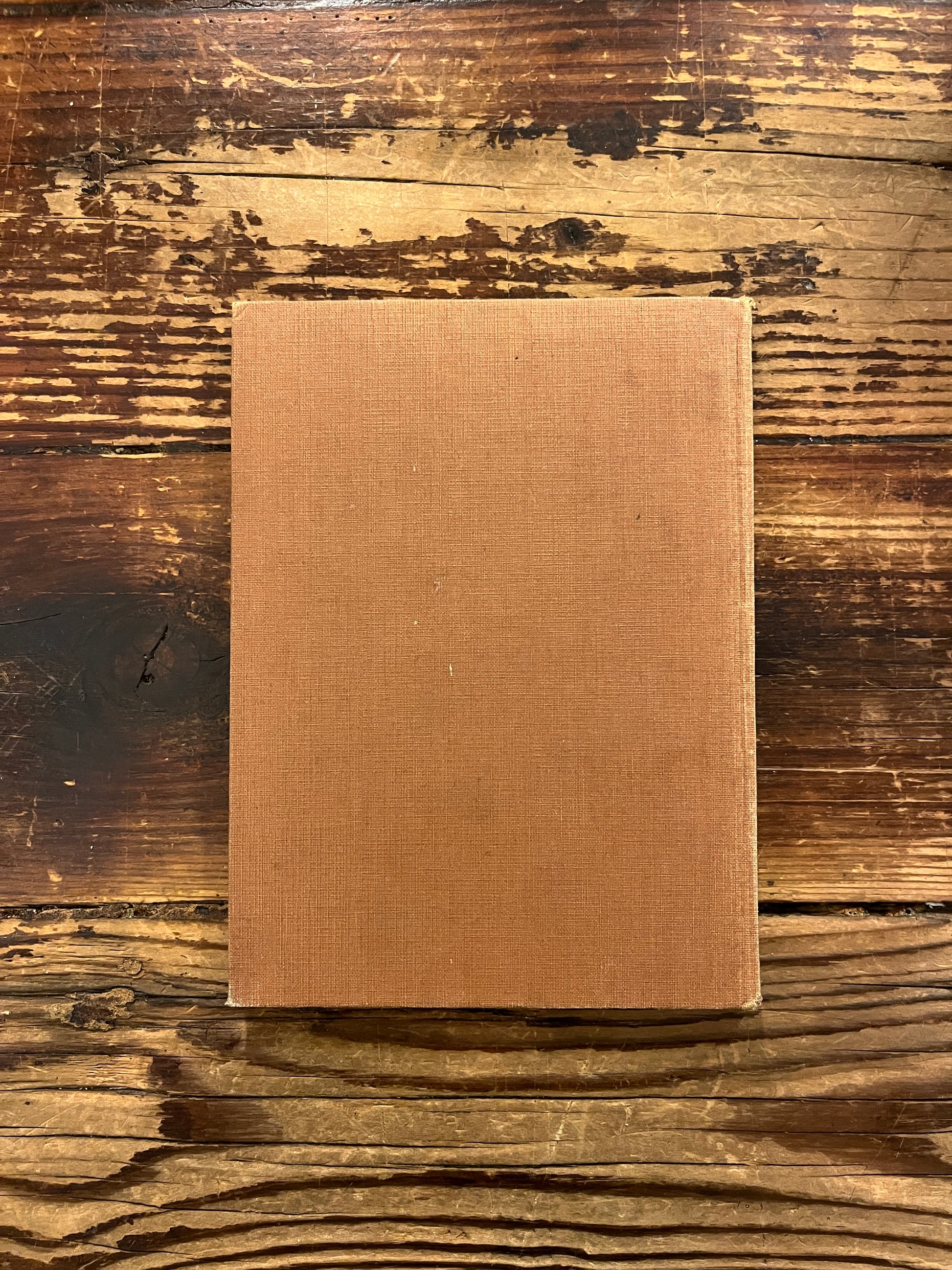 Back cover of book titled 'The Purpose of Life'  by Inayat Khan on a wooden surface