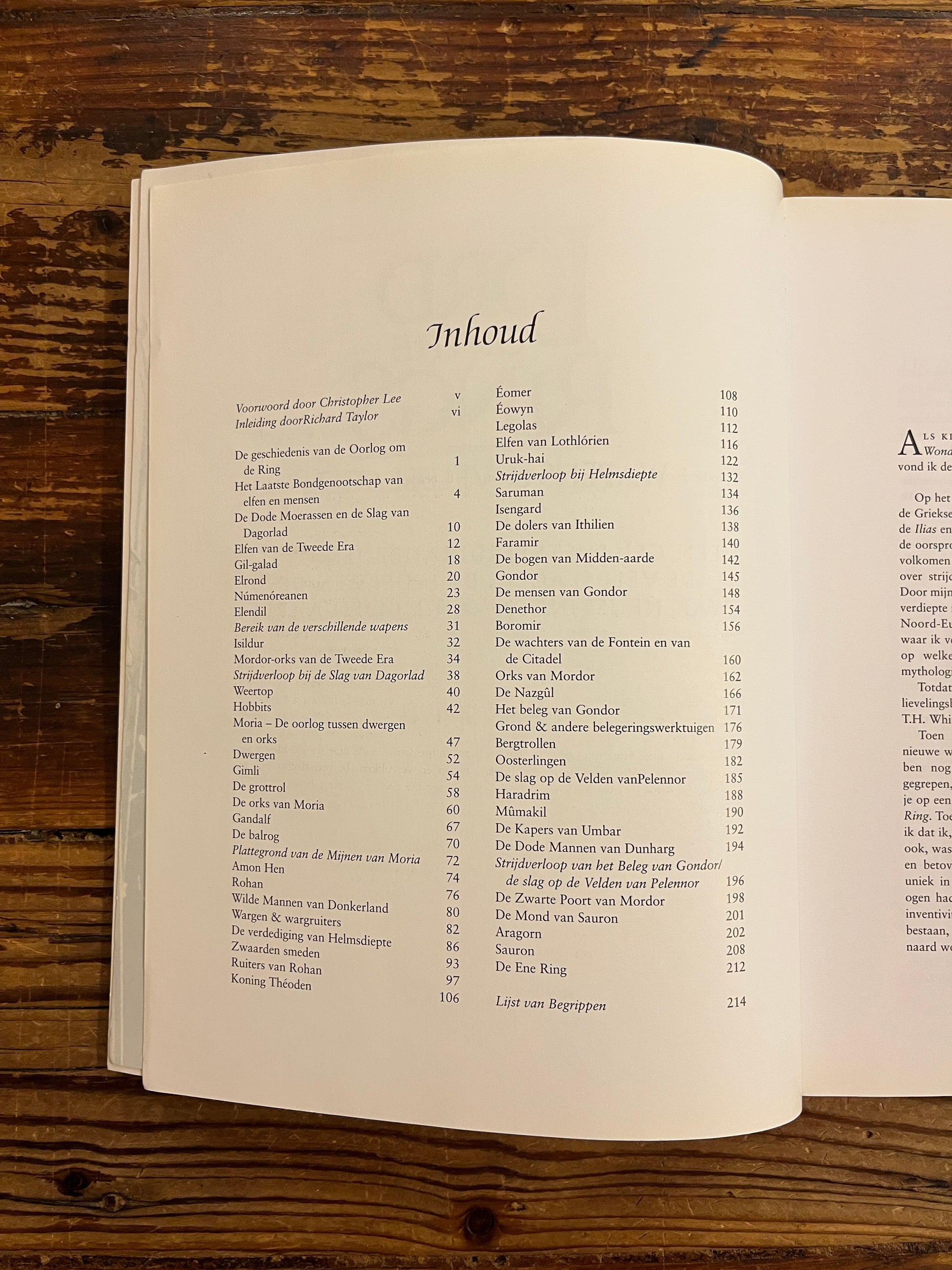 Inhoud van boek met de titel 'the lord of the rings, wapens en veldslagen' op een houten achtergrond 