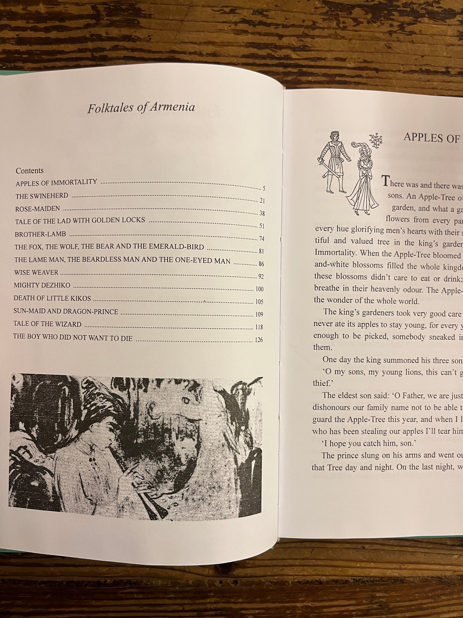 Open book titled 'Folktales of Armenia' on a wooden surface