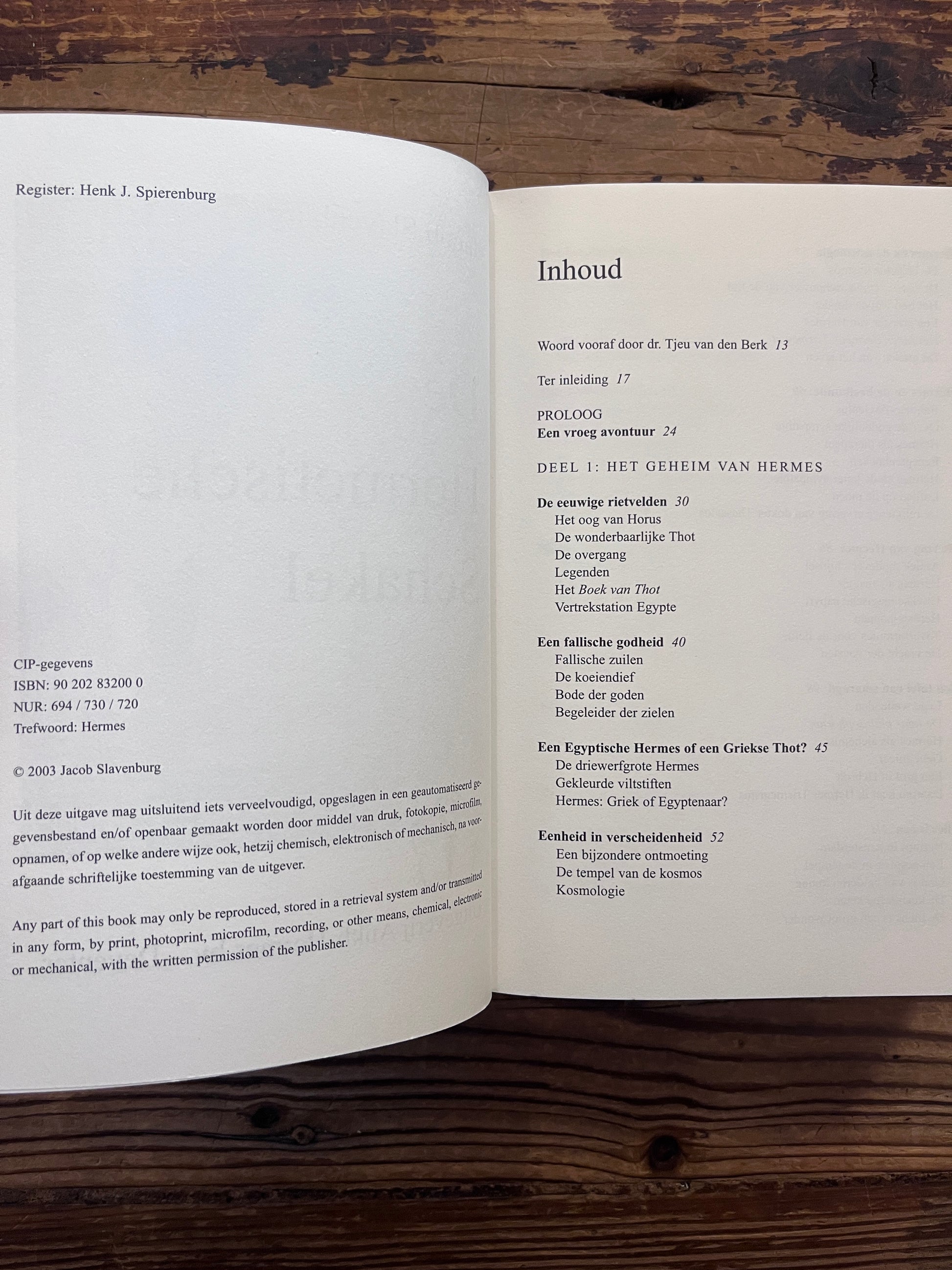 Open boek met de titel 'de Hermetische Schakel' door Jacob Slavenburg op een houten achtergrond 