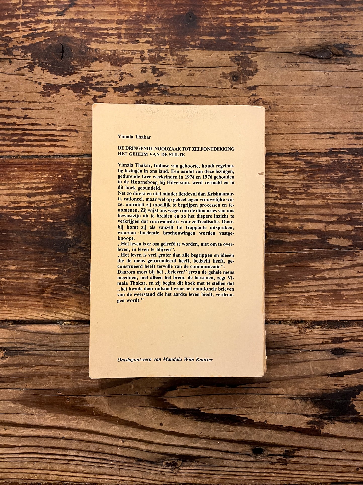 Achterkant van boek met de titel 'de dringende noodzaak tot zelfontdekking' door Vimala Thakar op een houten achtergrond 
