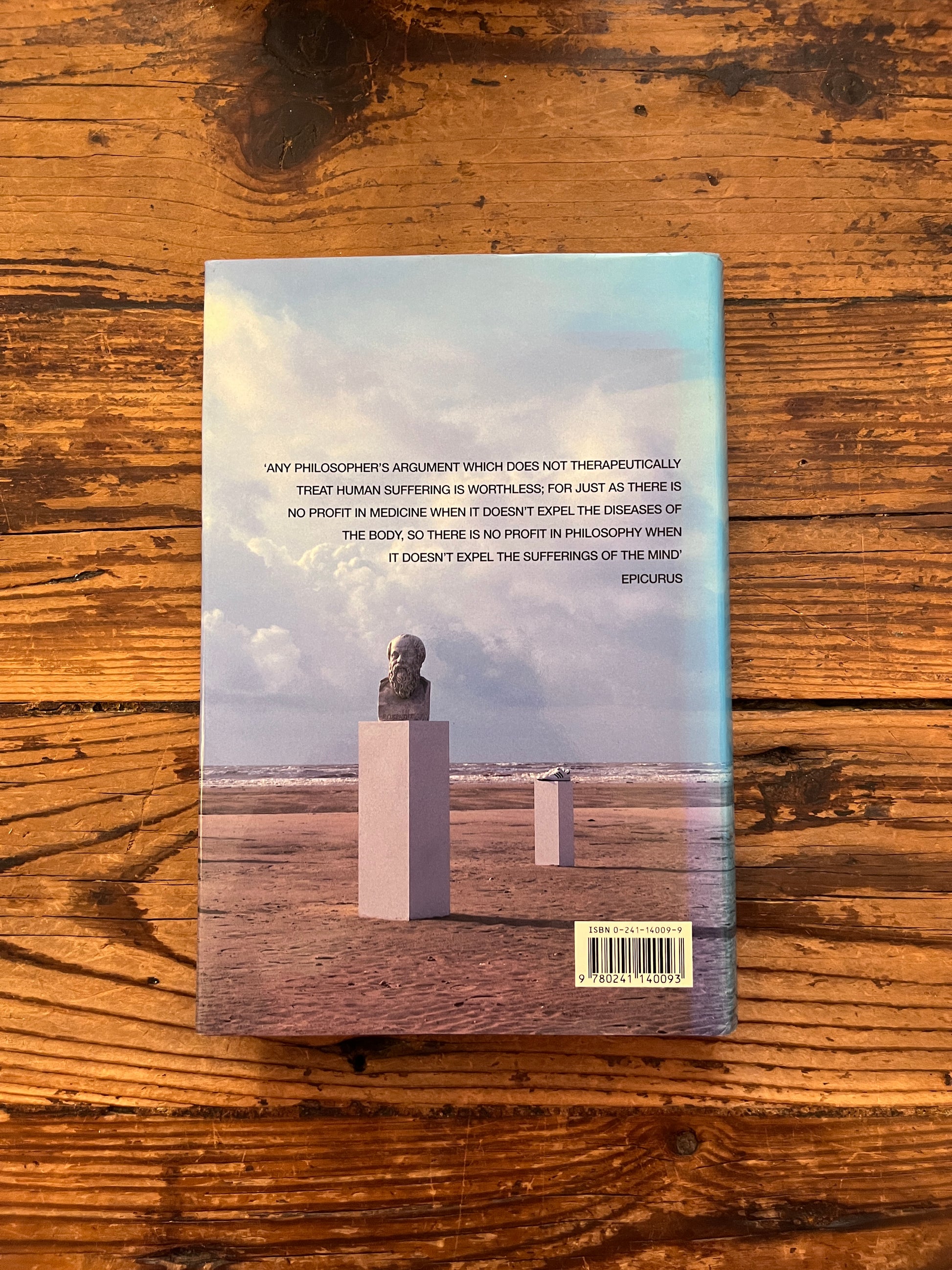 photo of the cover of the book "The consolation of philosophy" on a wooden backgrounds