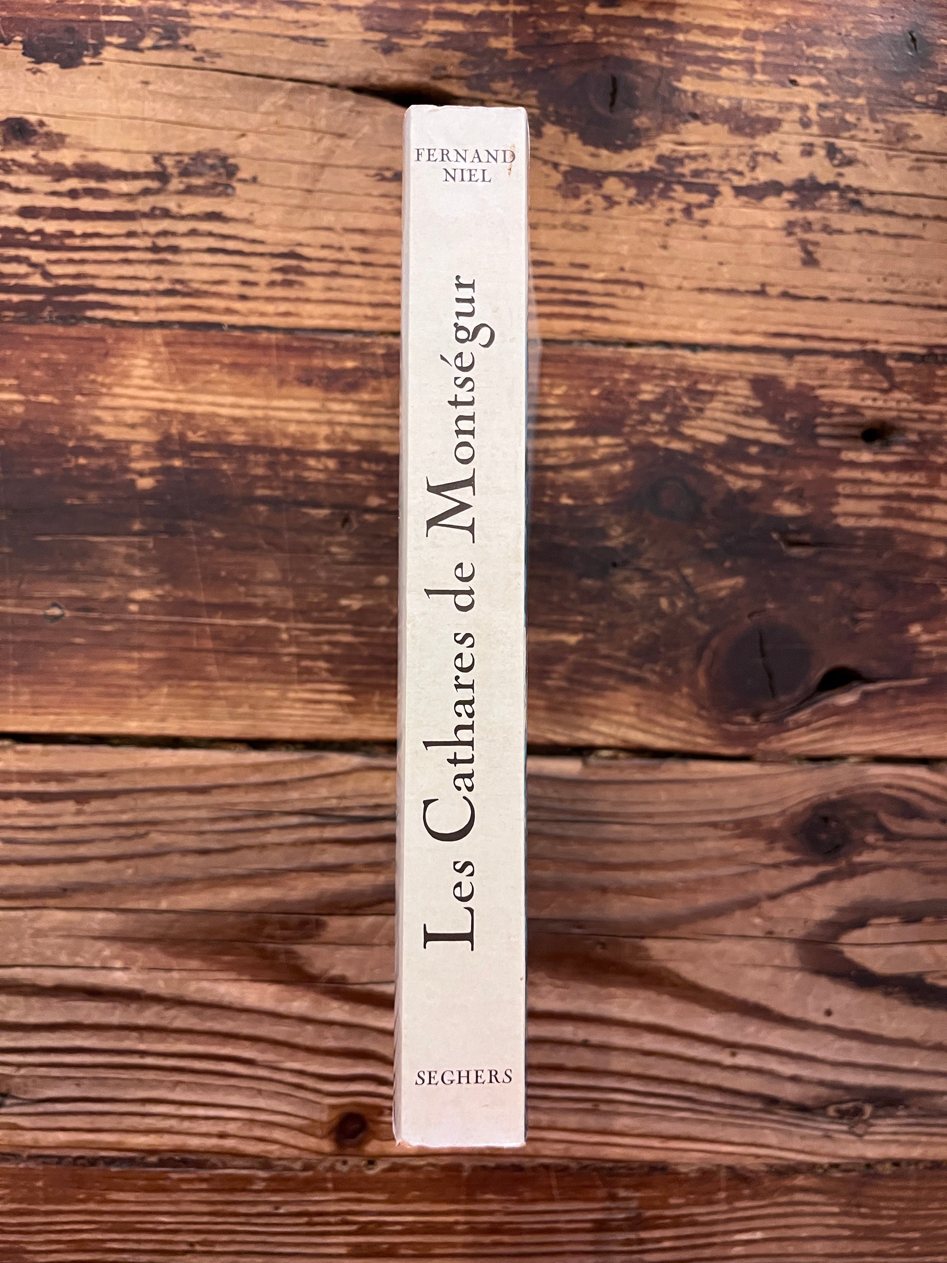photo de la tranche du livre "les cathares de montsegur"sur fond de bois