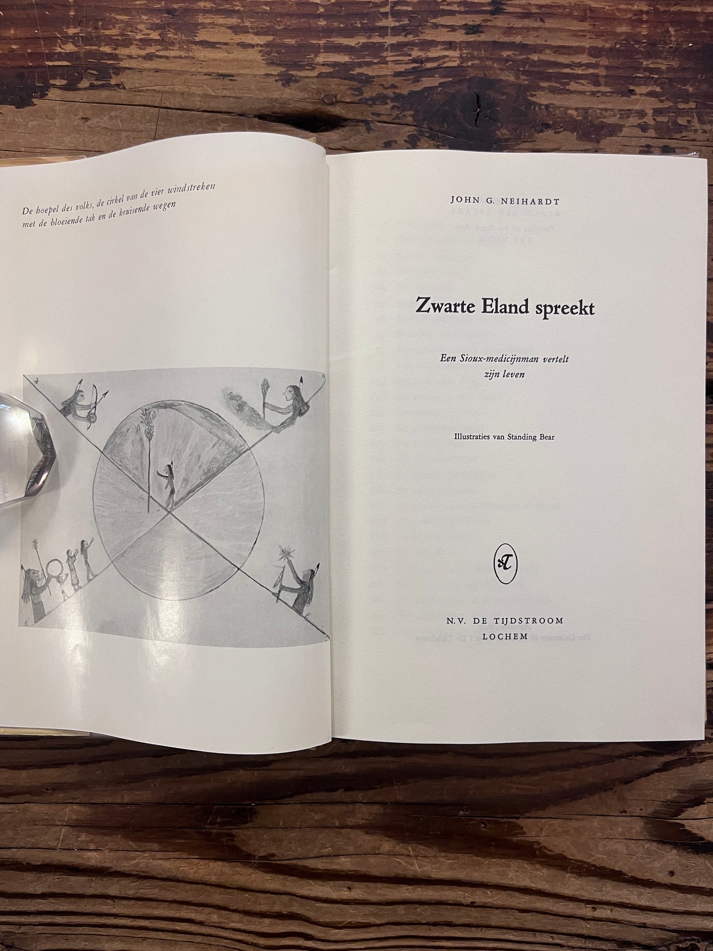 Open hardcover boek met de titel 'Zwarte eland spreekt, Een Sioux-medicijnman verteld zijn leven' door John G. Neihardt op een houten achtergrond 