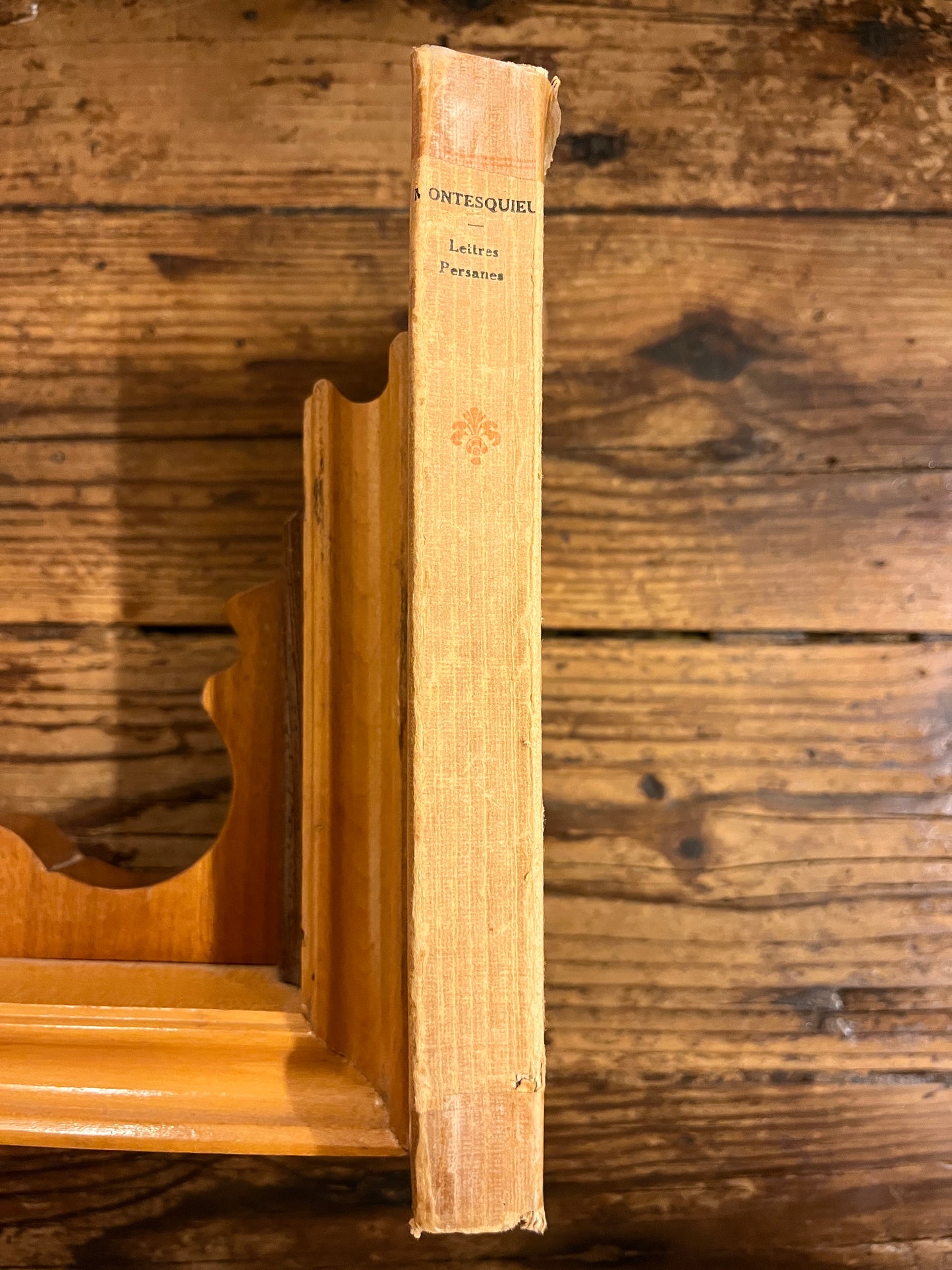 dos du livre  "lettres persannes" sur fond de bois 
