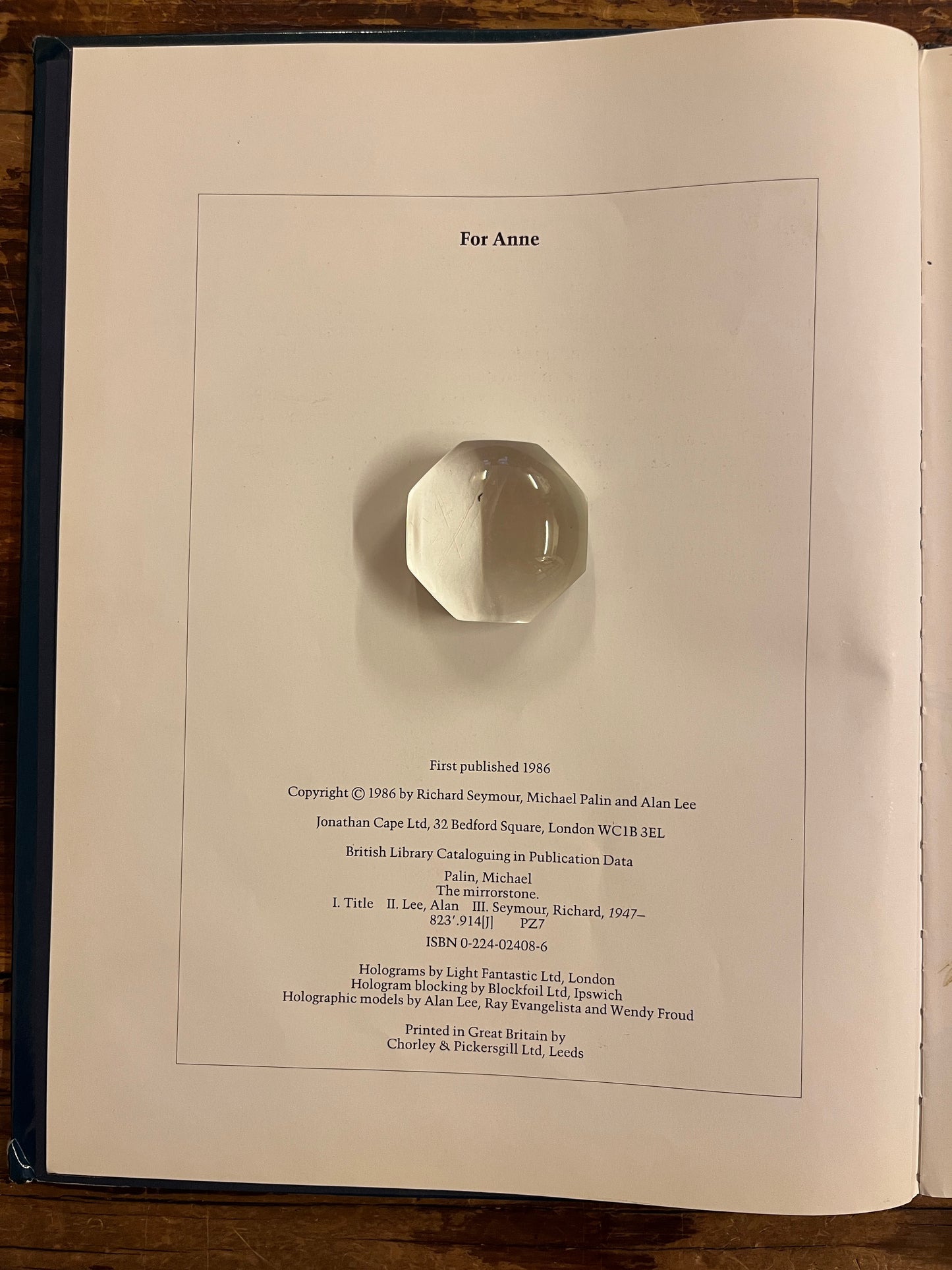 open book titled 'The Mirrorstone' on a wooden surface