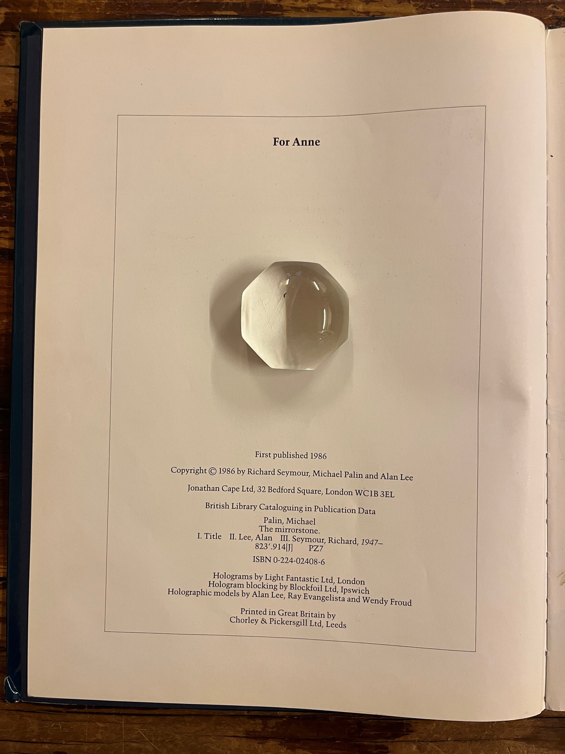 open book titled 'The Mirrorstone' on a wooden surface