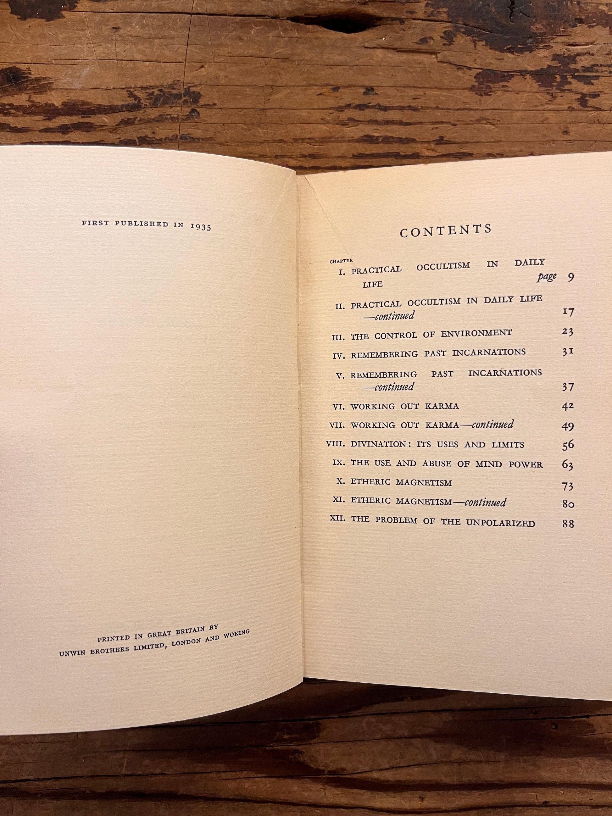 Open rare book with the title 'practical occultism' by Dion Fortune on a wooden surface 