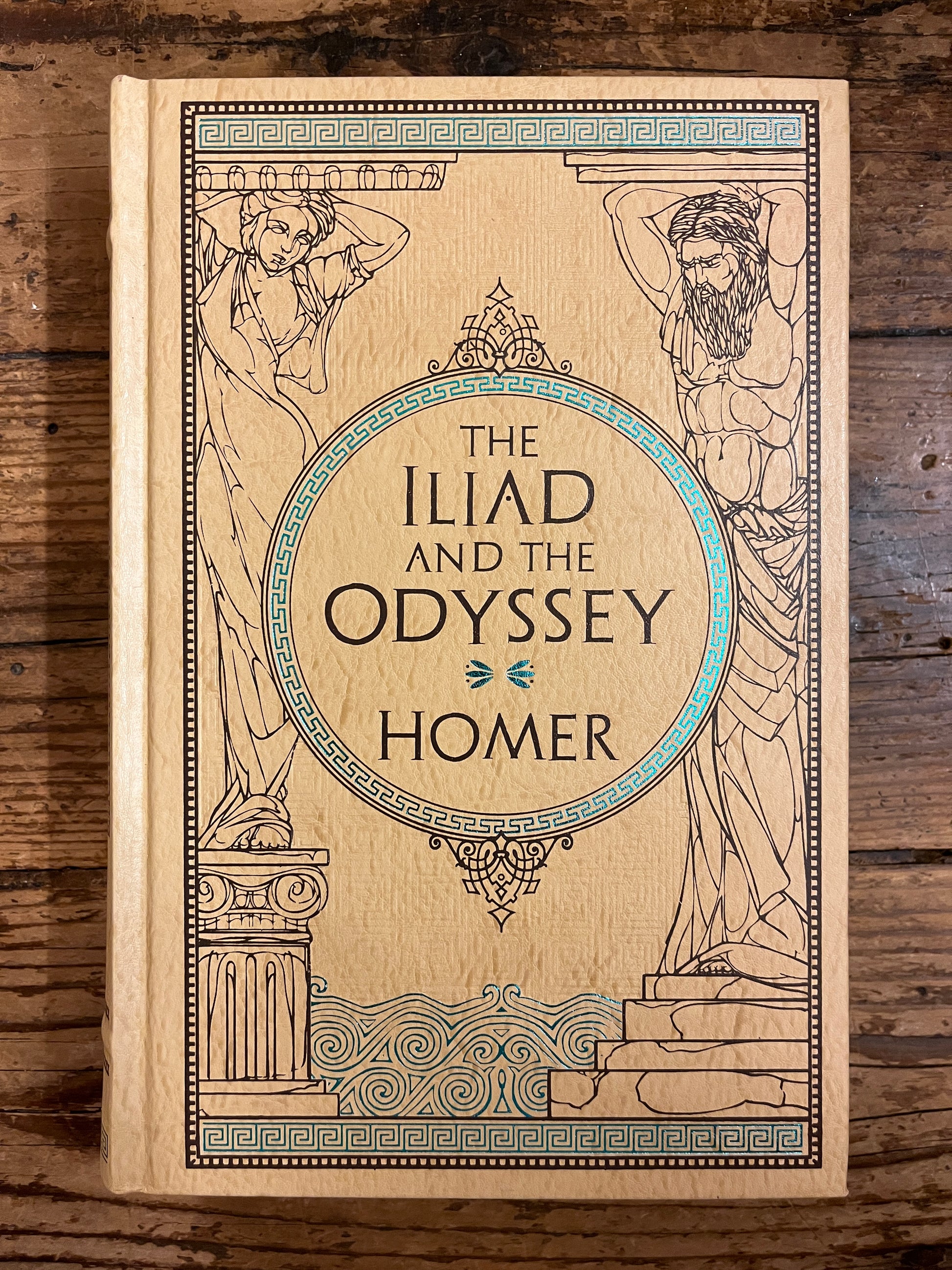 photo of the cover of the book "the iliad and the odyssey" on a wooden background
