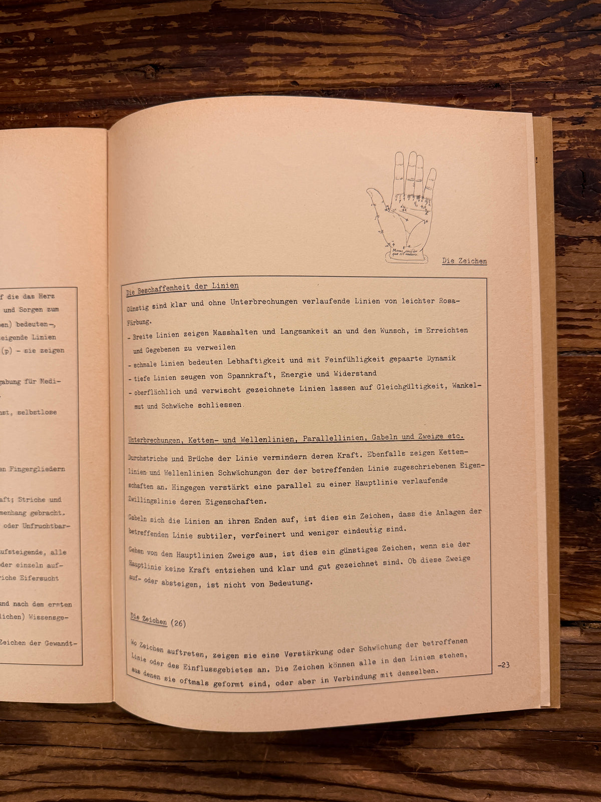 Open paperback with illustrations of 'Simmen's Portfolio No. 1: Die glückliche Hand' on a wooden background 