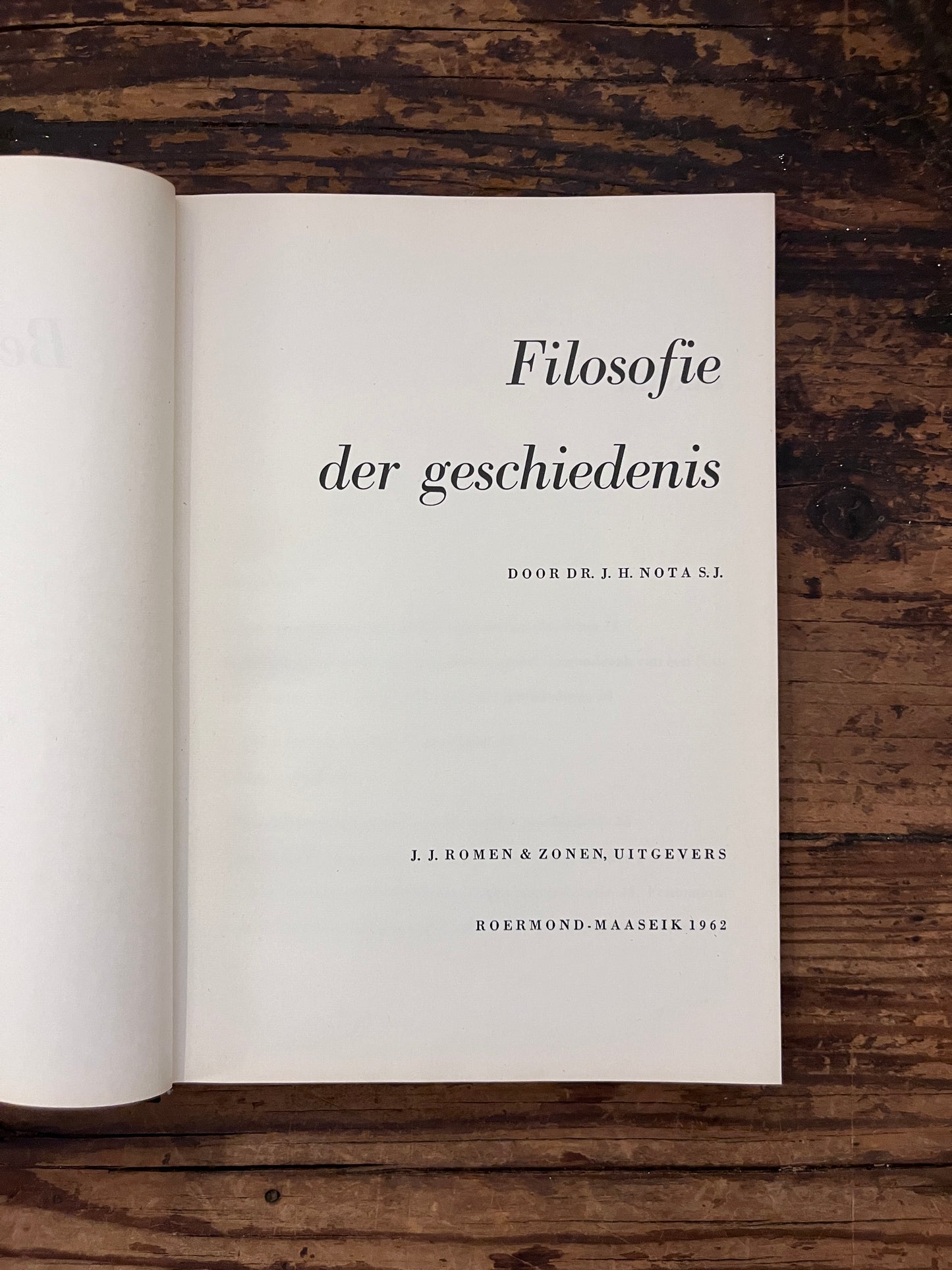 foto van de titel pagina van het boek "filosofie der geschiedenis" op een houten achtergrond