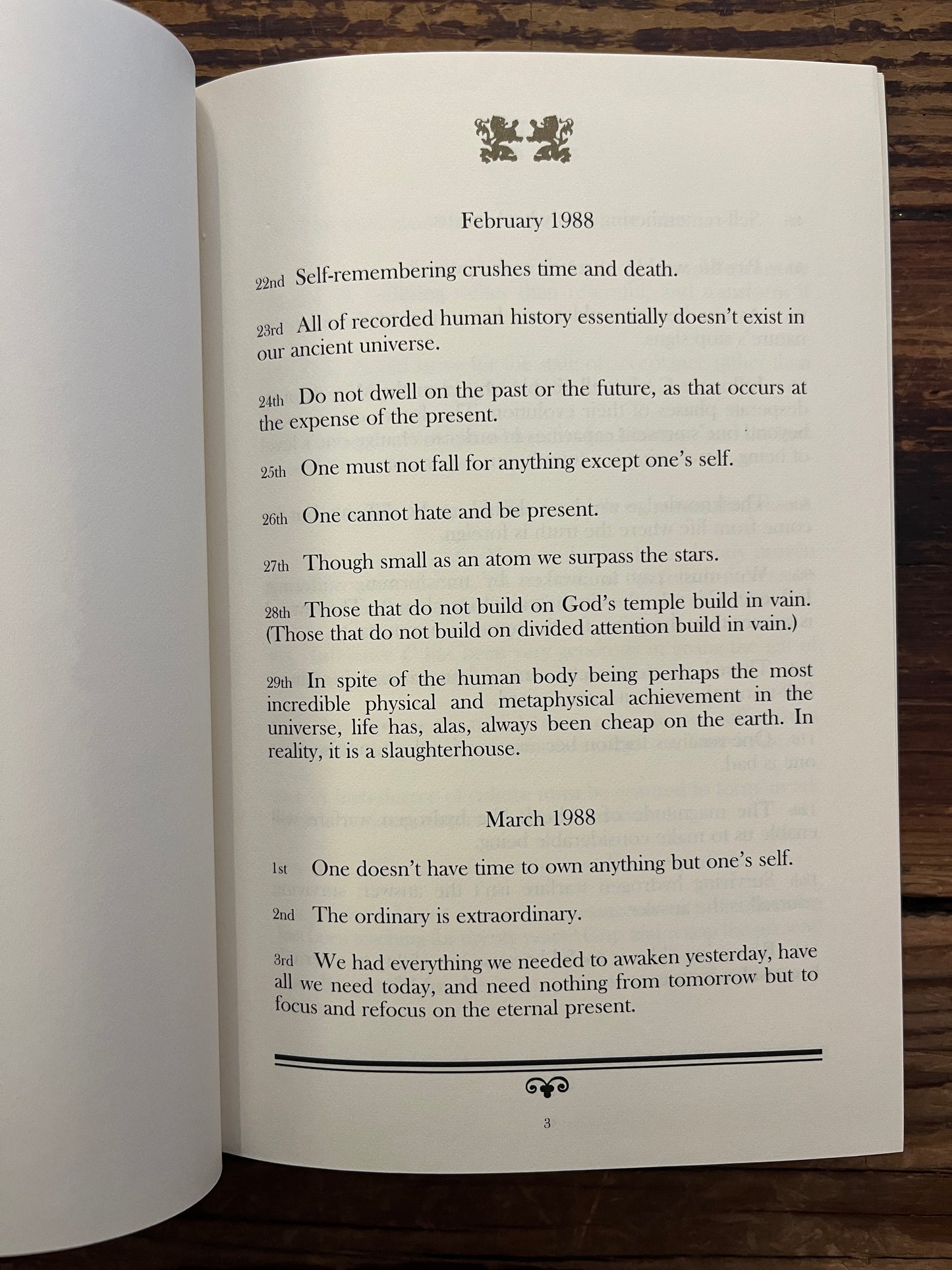 Open book with the title 'Ten Years of Daily Cards' by Robert Burton on a wooden surface