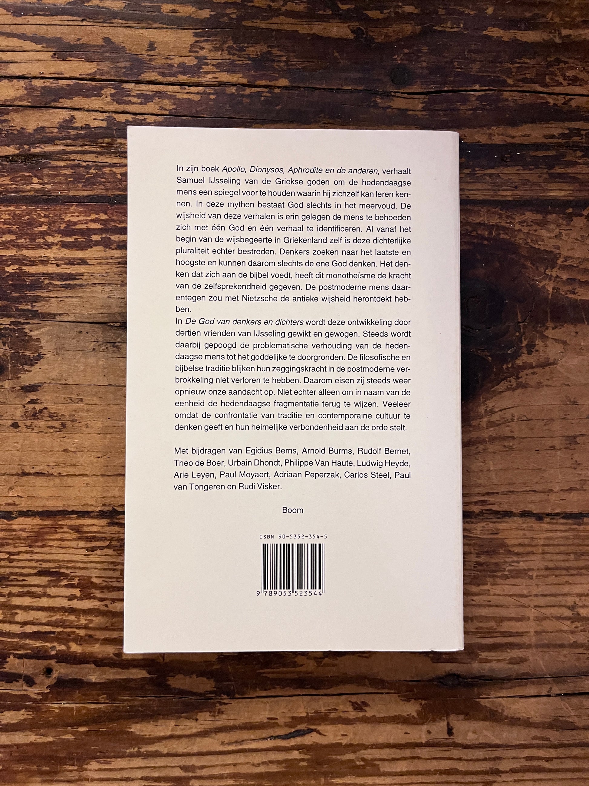 foto van de cover van "de god van denkers en dichters" op een houte achtergrond