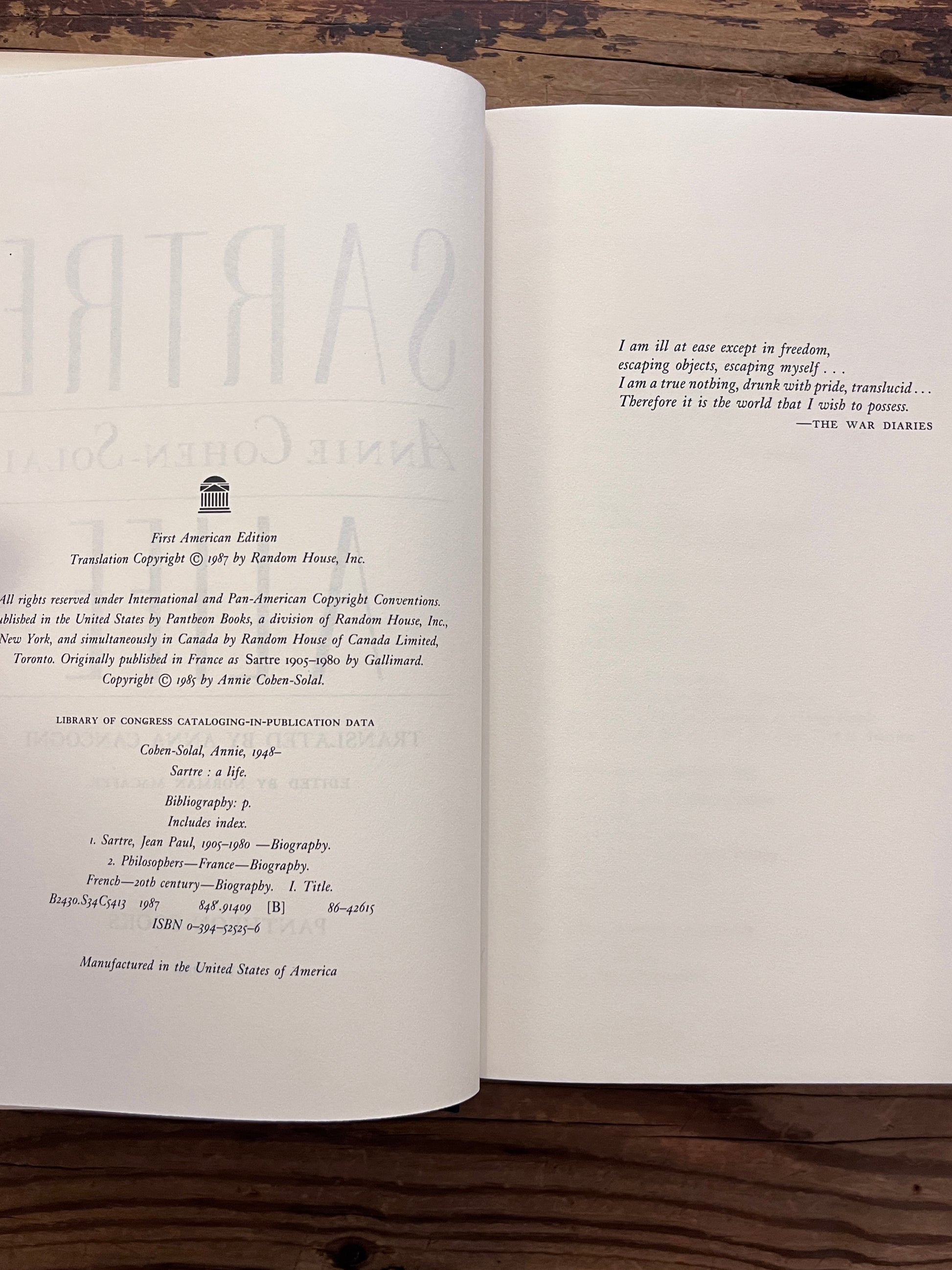 photo of the haldf title page of the book "sartre"on a wooden background