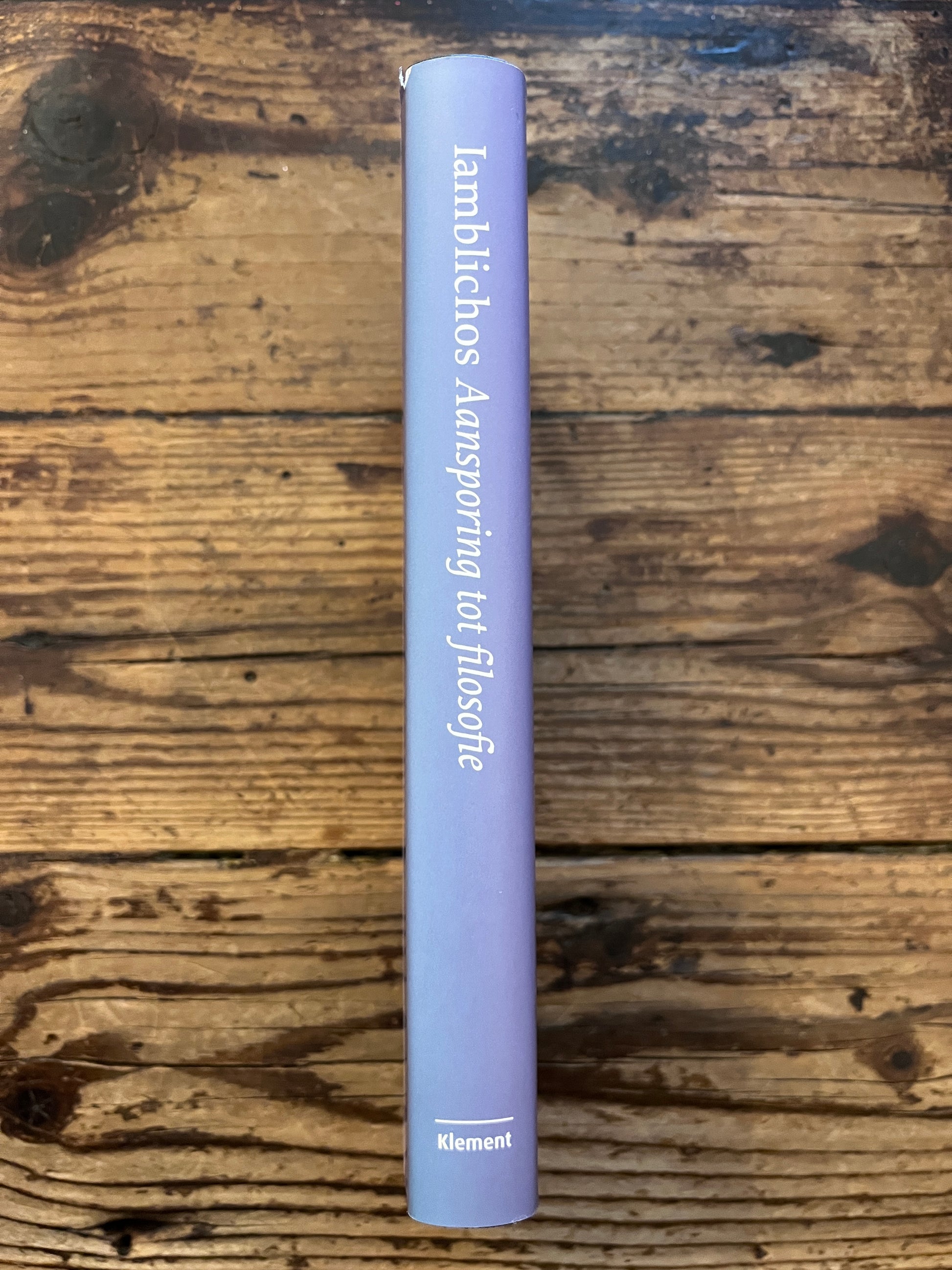 foto van de rug van het boek "aansporing tot filosofie" op houten achtergrond