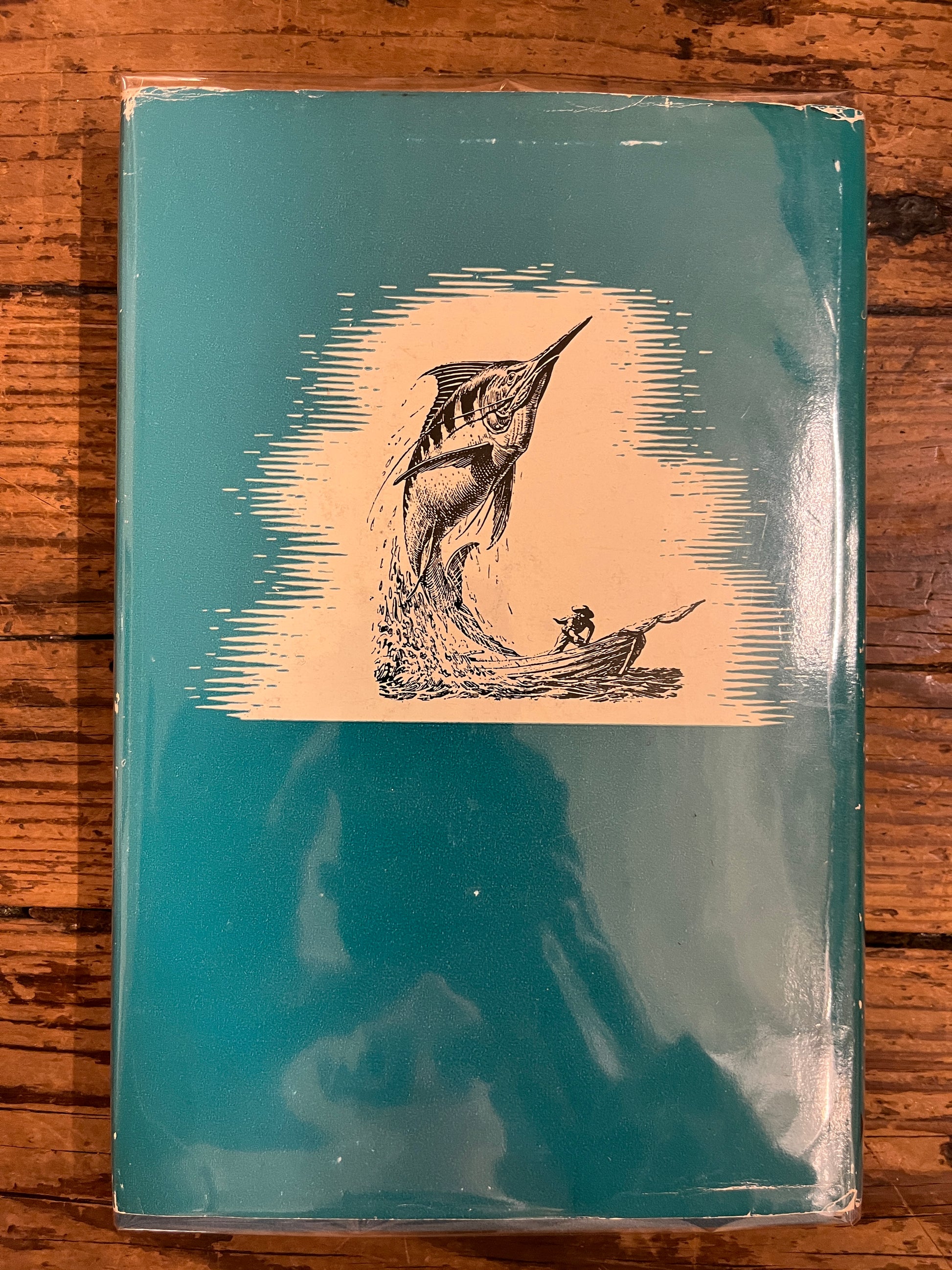 photo of the backcover of the book "the old man and the sea"on a wooden background