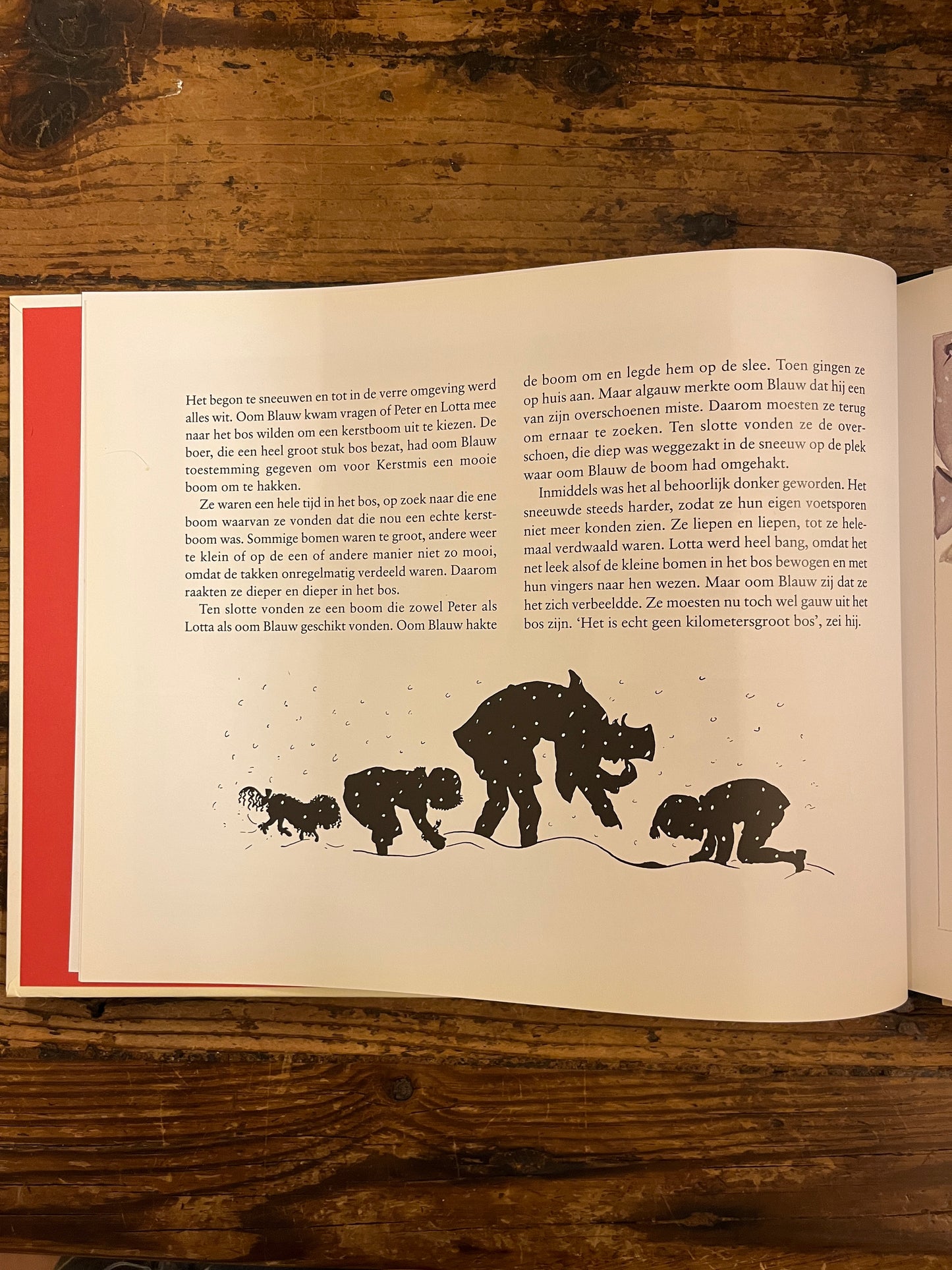 uitzicht op een tekst pagina uit het boek "Peter en lotta vieren kerstfeest op houten achtergrond
