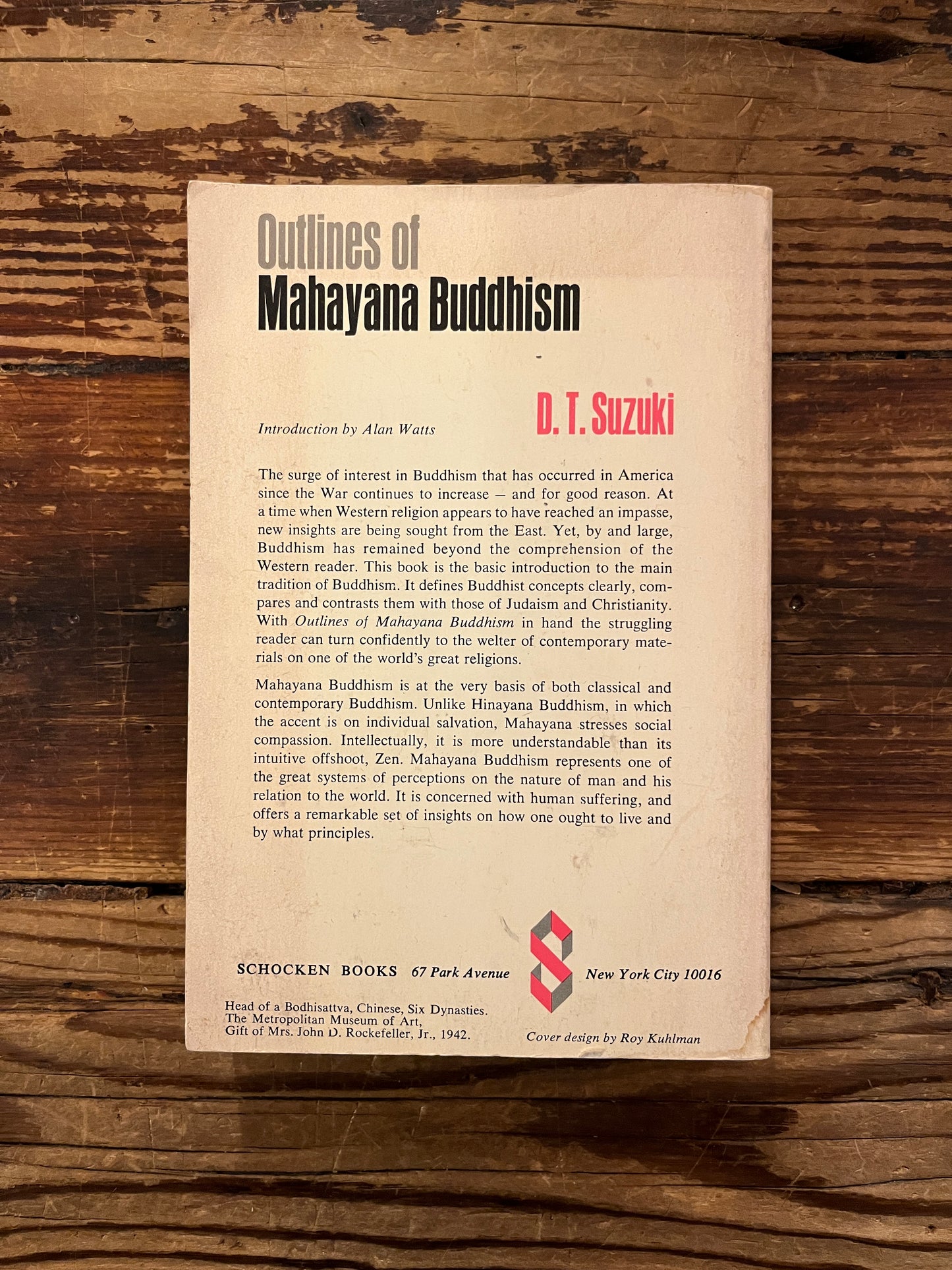 Back cover of 'Outlines of Mahayana Buddhism' by D.T. Suzuki on a wooden surface