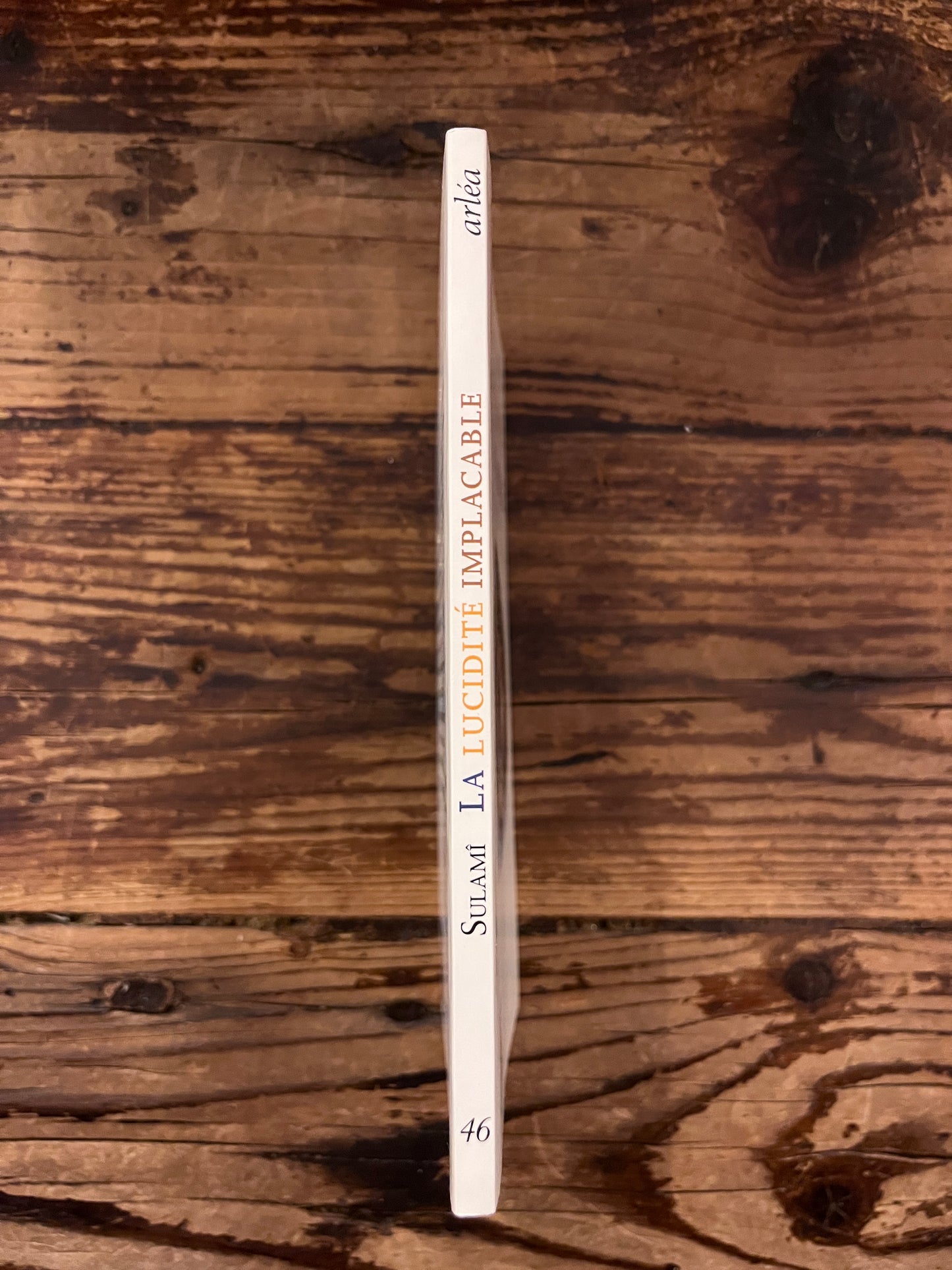 photo de la tranche du livre "la lucidite implacable" sur fond de bois