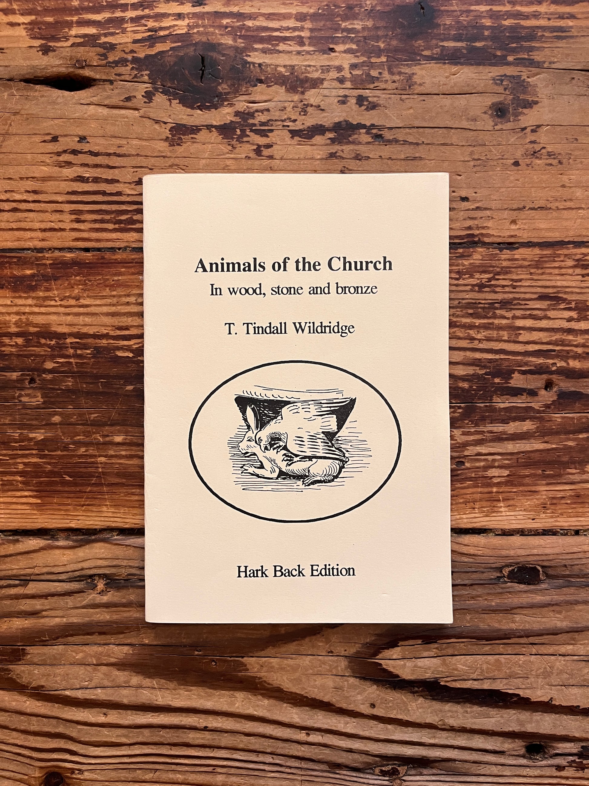 Front cover of a booklet with the title 'Animals of the chruch' by T. Tindall Wildridge on a ooden surface 