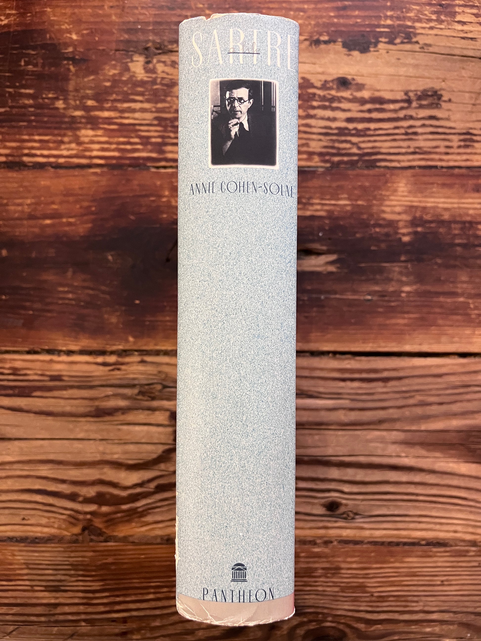photo of the spine of the book "sartre"on a wooden background