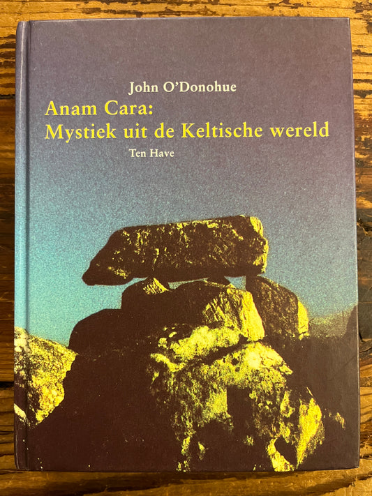 Boek met de titel 'Anam Cara: Mystiek uit de Keltische wereld' door John O'Donohue op een houten achtergrond 