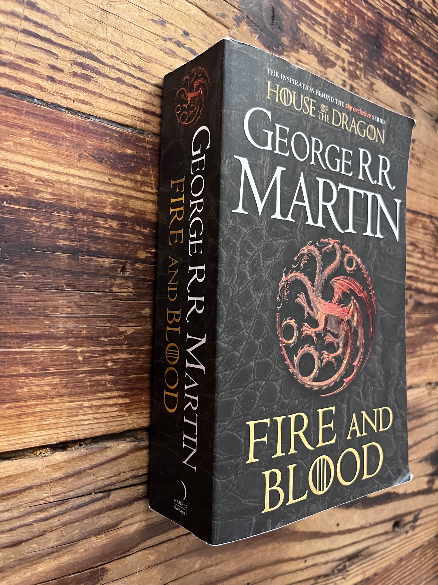 Book titled 'Fire and Blood' by George R.R. Martin on a wooden surface