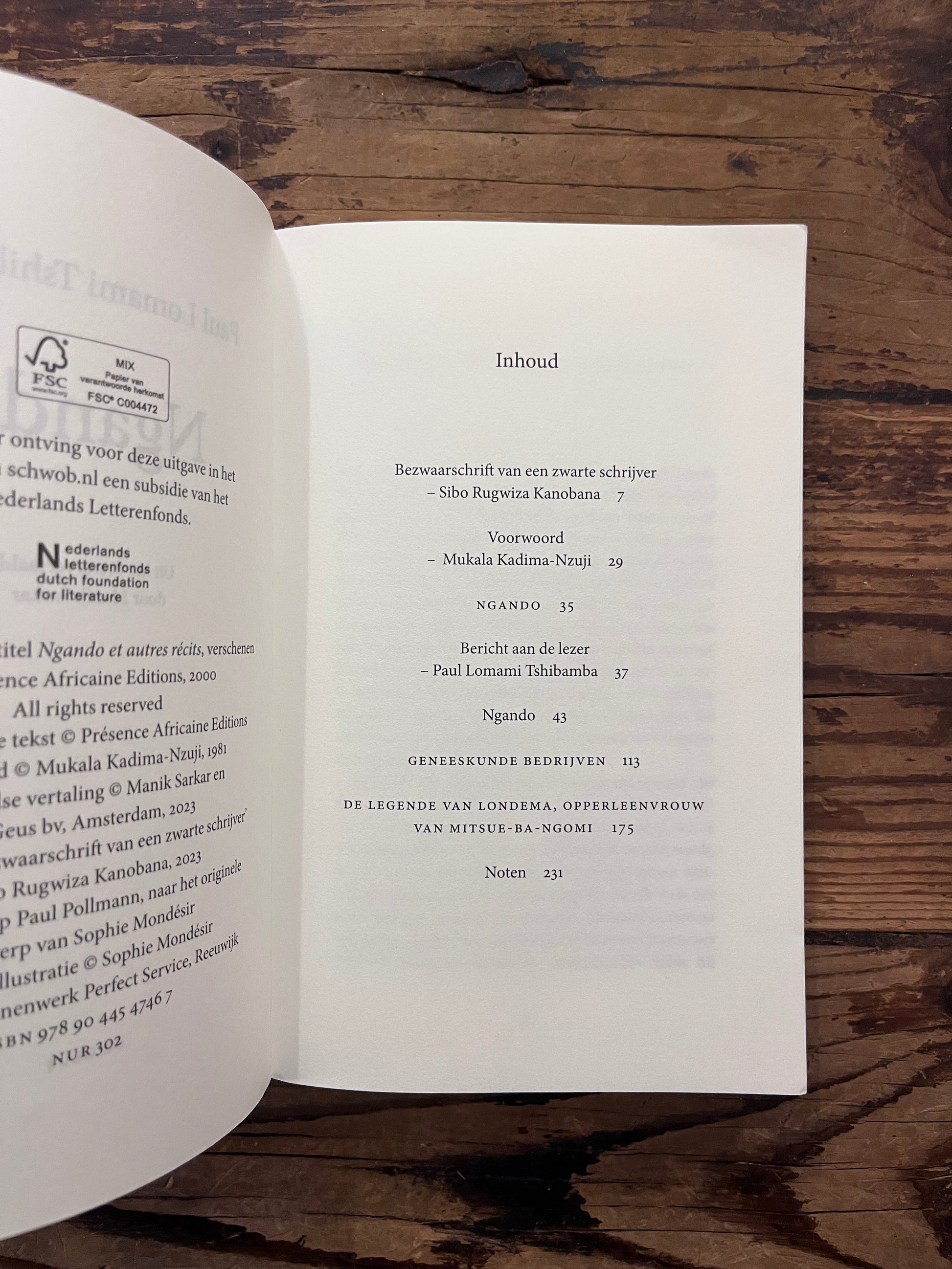 Open boek met de titel 'Ngando' door Paul Lomami Tshibamba op een houten achtergrond 
