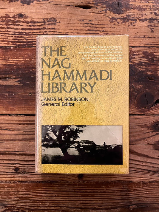 Front cover of book titled 'The Nag Hammadi Library in English' on a wooden surface