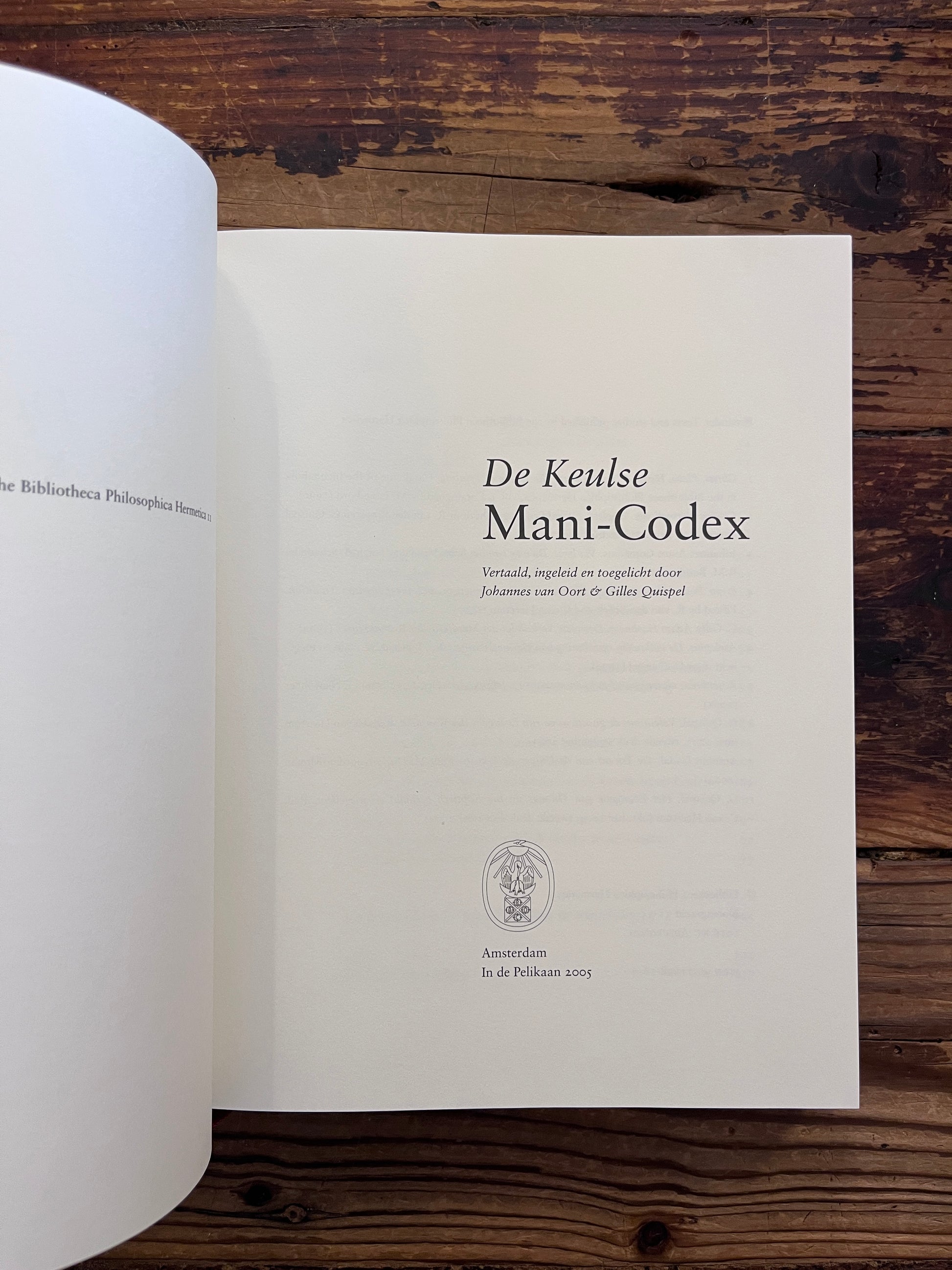 Open boek met de titel 'de Keulse Mani-Codex' op een houten achtergrond 