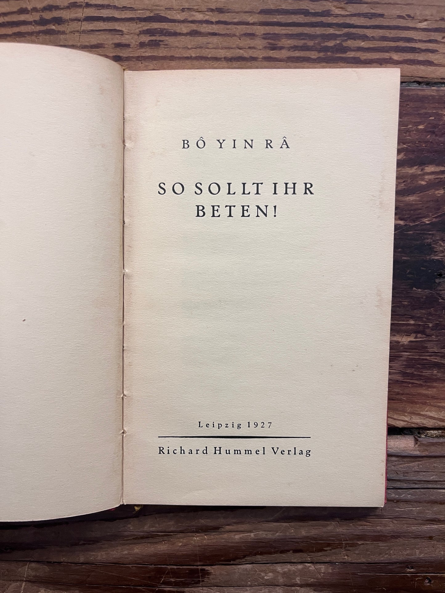 First page of booklet with the title 'So Sollt Ihr Beten' by Bo Yin Ra on a wooden surface 